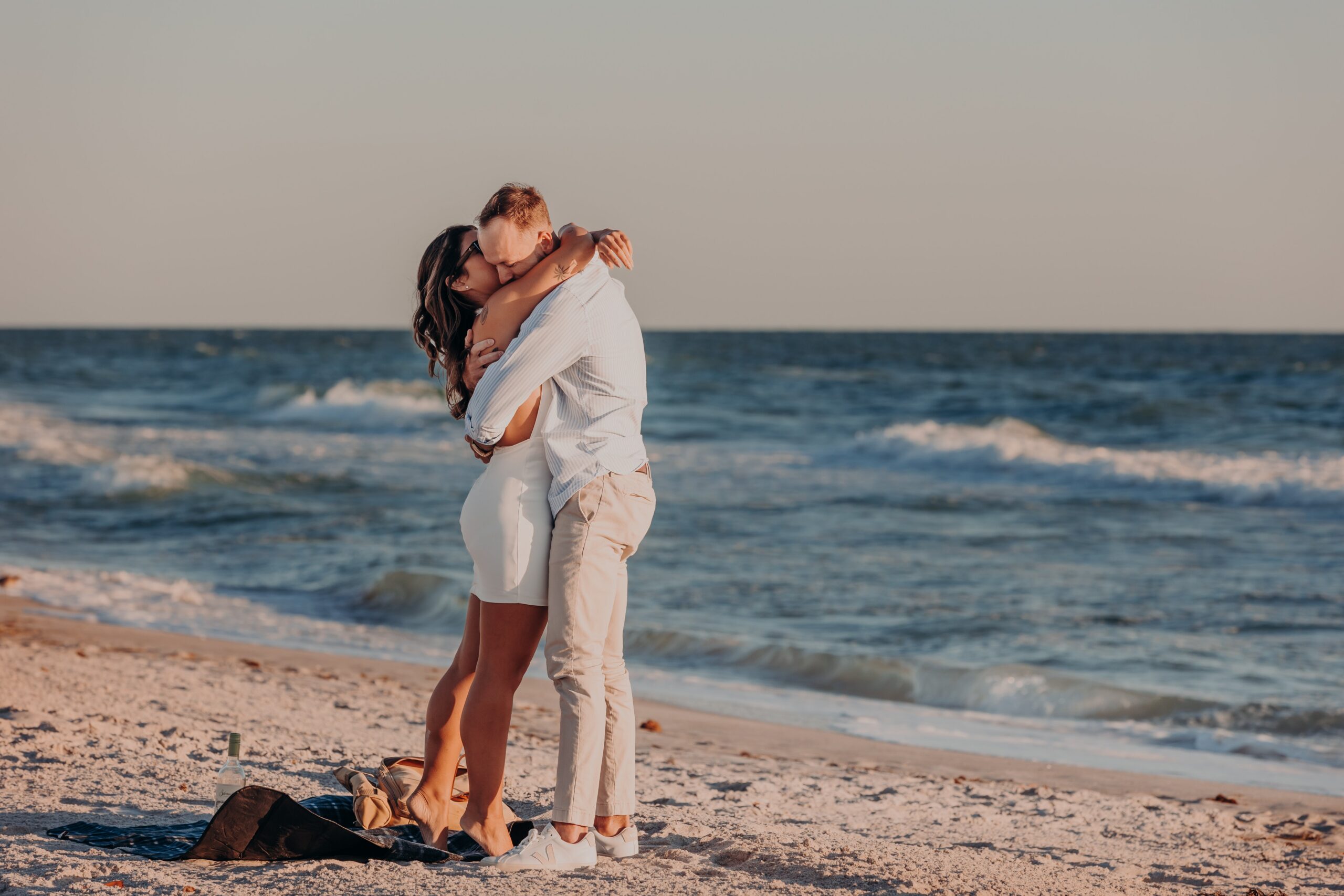 Bianca and Patrick golden hour portrait on Longboat Key beach after their surprise proposal, warm sunset light with Gulf of Mexico in background, photographed by Angela Moon Photography