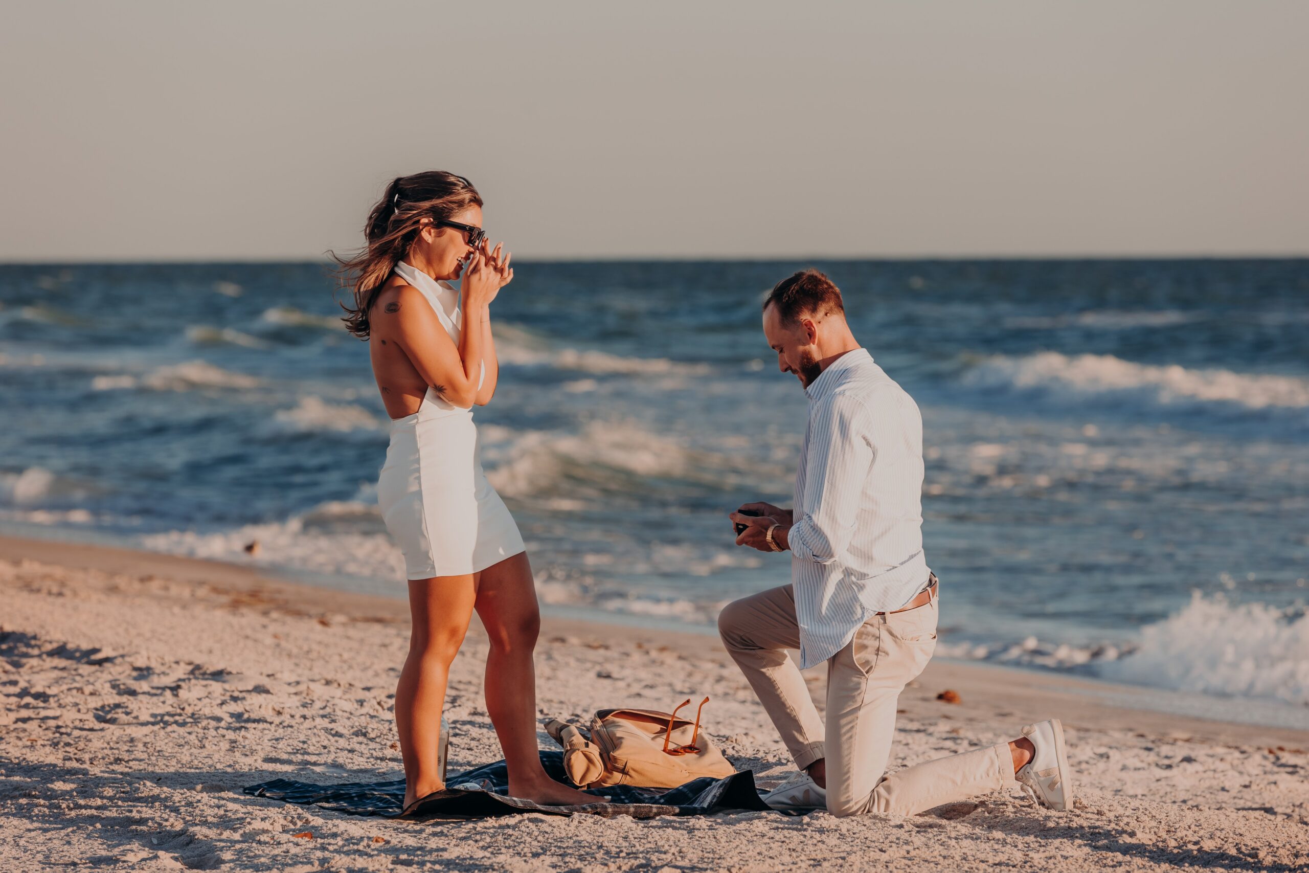 Bianca and Patrick embracing on the beach immediately after he proposed on Longboat Key Florida, just engaged, photographed by Sarasota proposal photographer Angela Moon