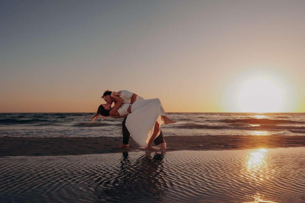 Siesta Key beach proposal at sunset with couple kissing in shallow water