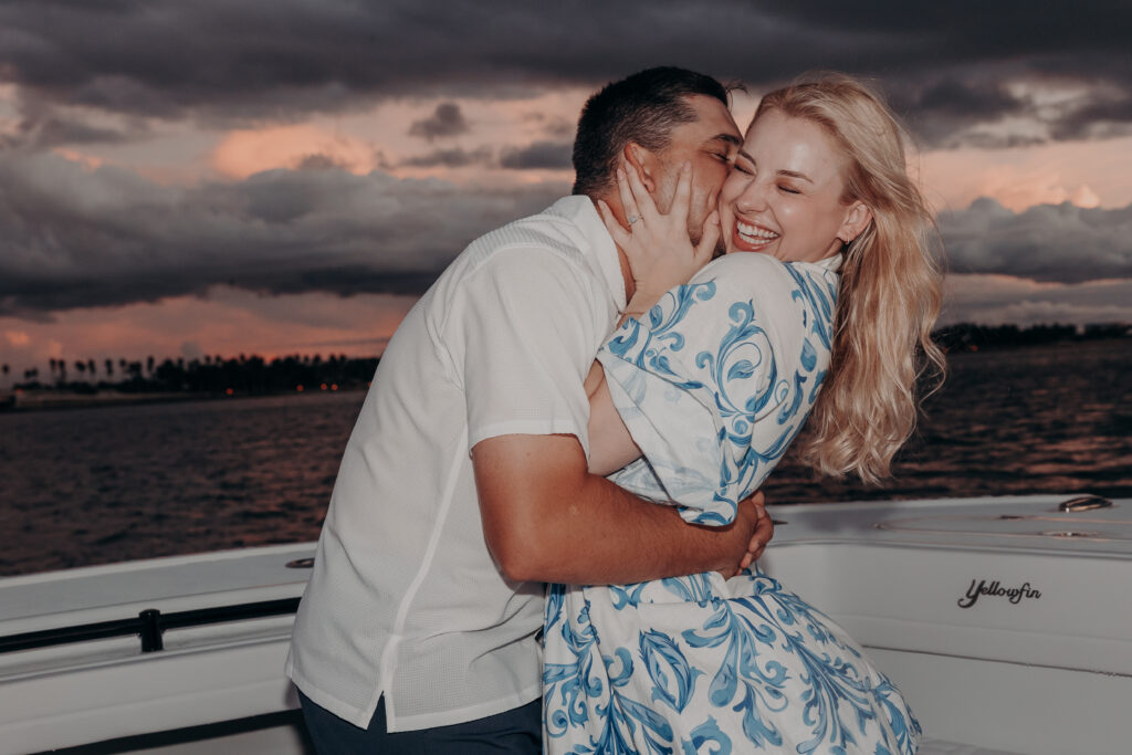 Just engaged couple embracing on a boat in Sarasota during sunset