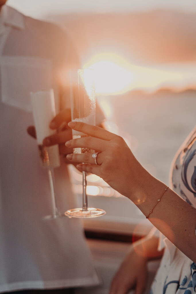 Proposal celebration on a boat in Sarasota at sunset with champagne and engagement ring