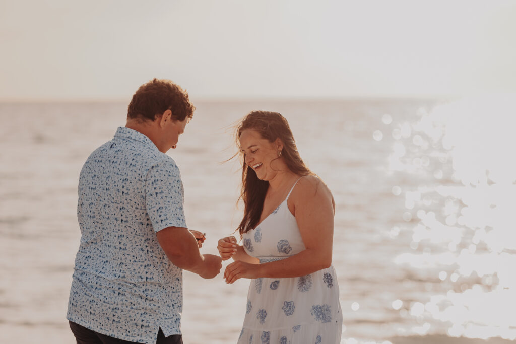 Couple celebrating engagement on Longboat Key beach after proposal