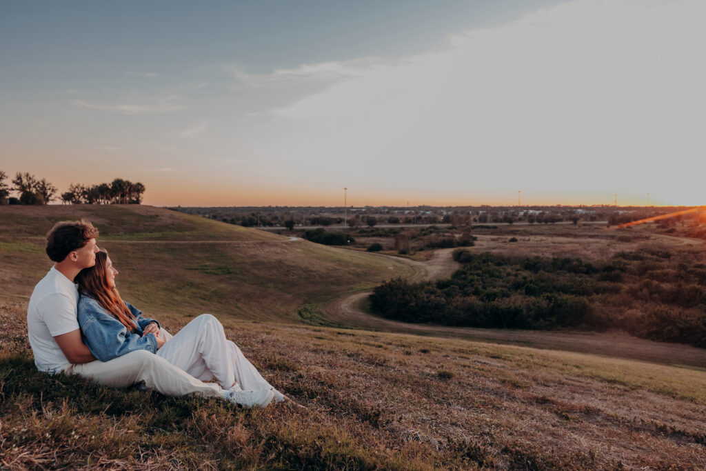 Couple sitting together at sunset overlooking Celery Fields in Sarasota during proposal session