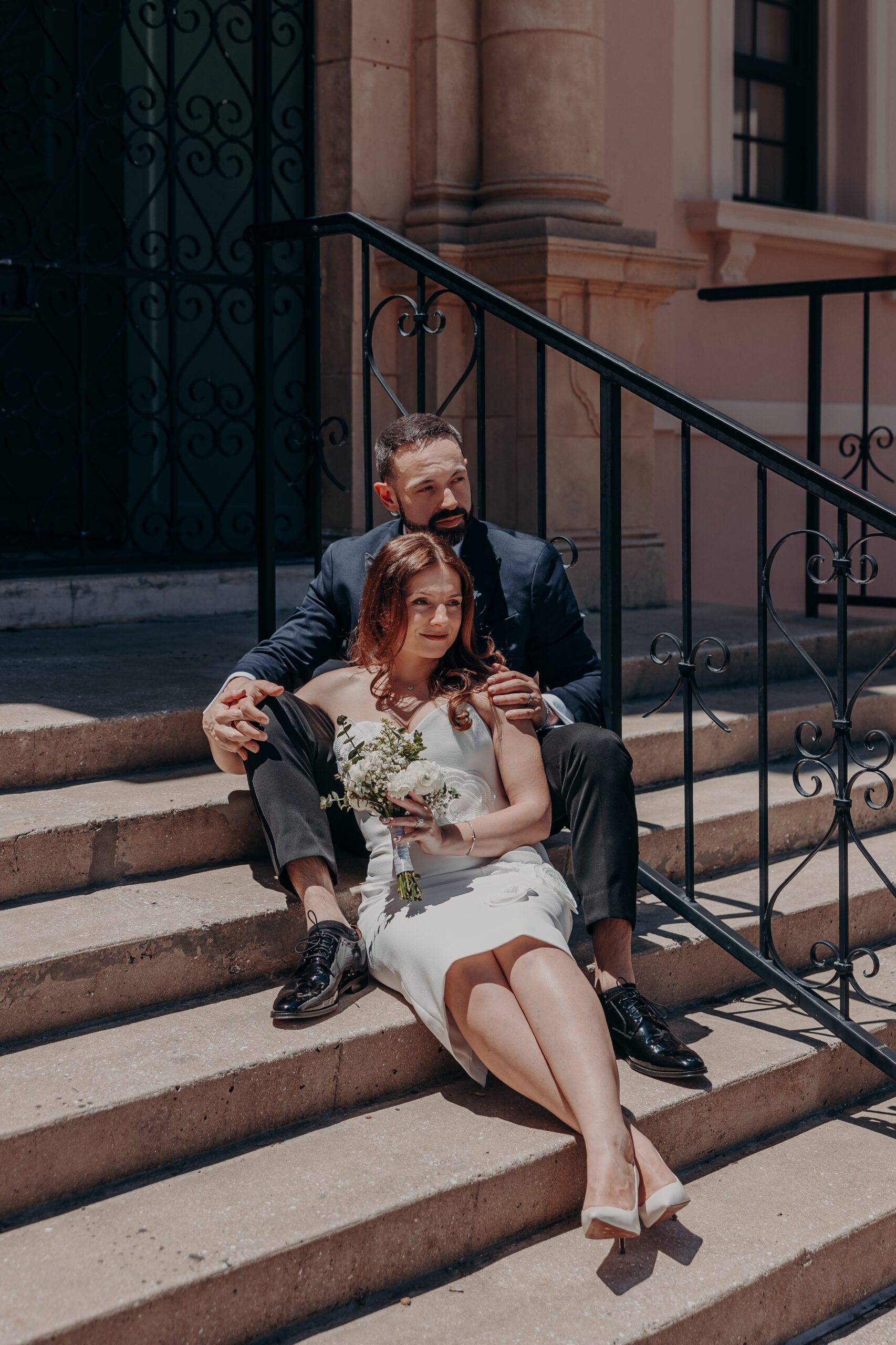 Diana and Robert sitting together on the outdoor stone steps at the Historic Sarasota County Courthouse in Sarasota FL