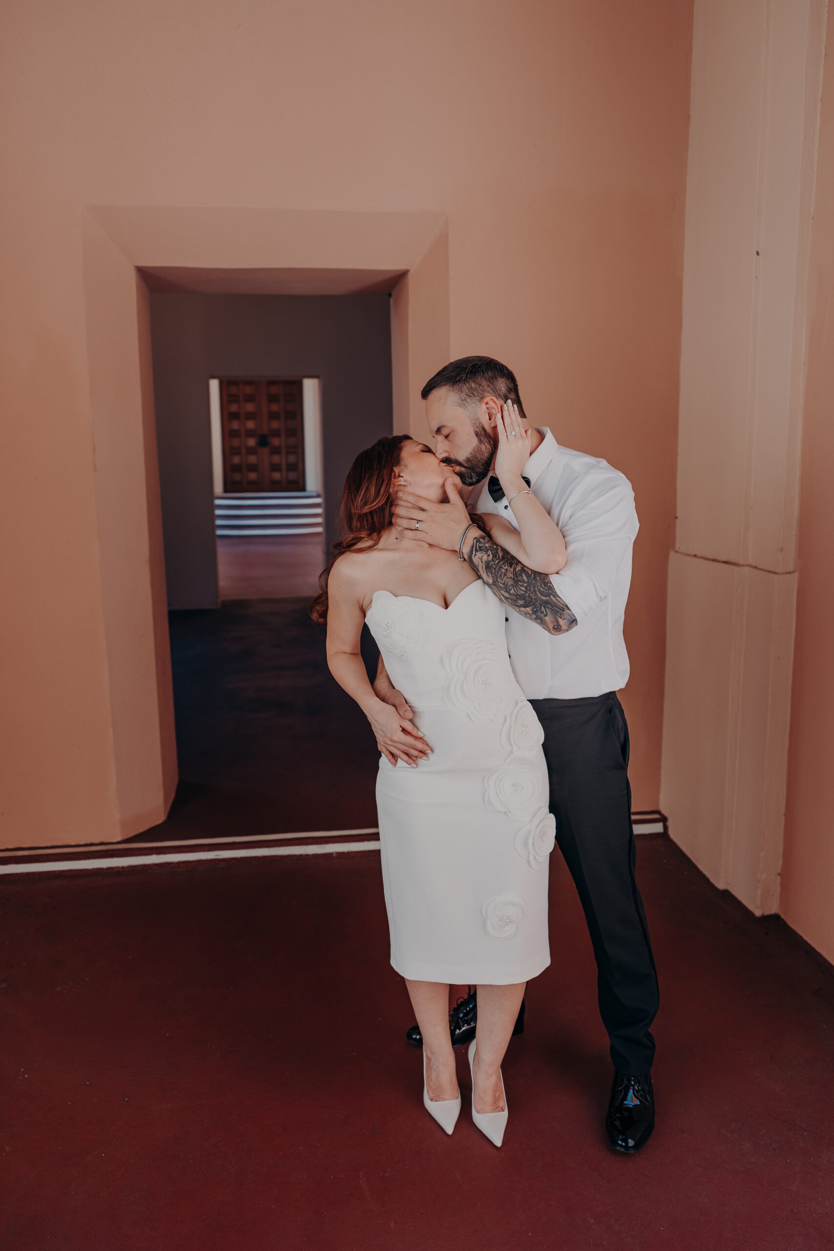 Diana and Robert kissing in the archway corridor of the Historic Sarasota County Courthouse during their elopement