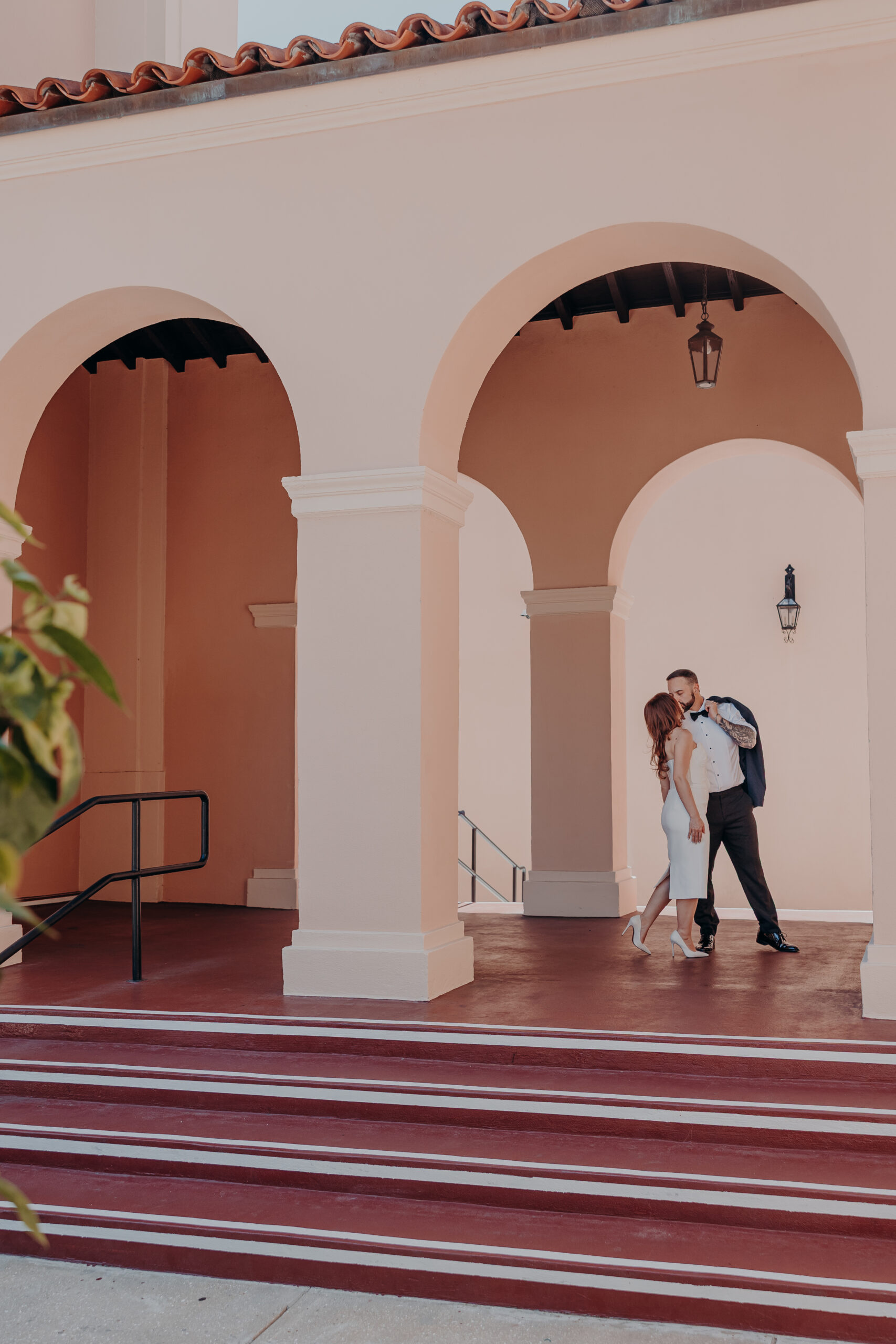 Diana and Robert kissing under the Spanish colonial arches outside the Historic Sarasota County Courthouse in Sarasota Florida