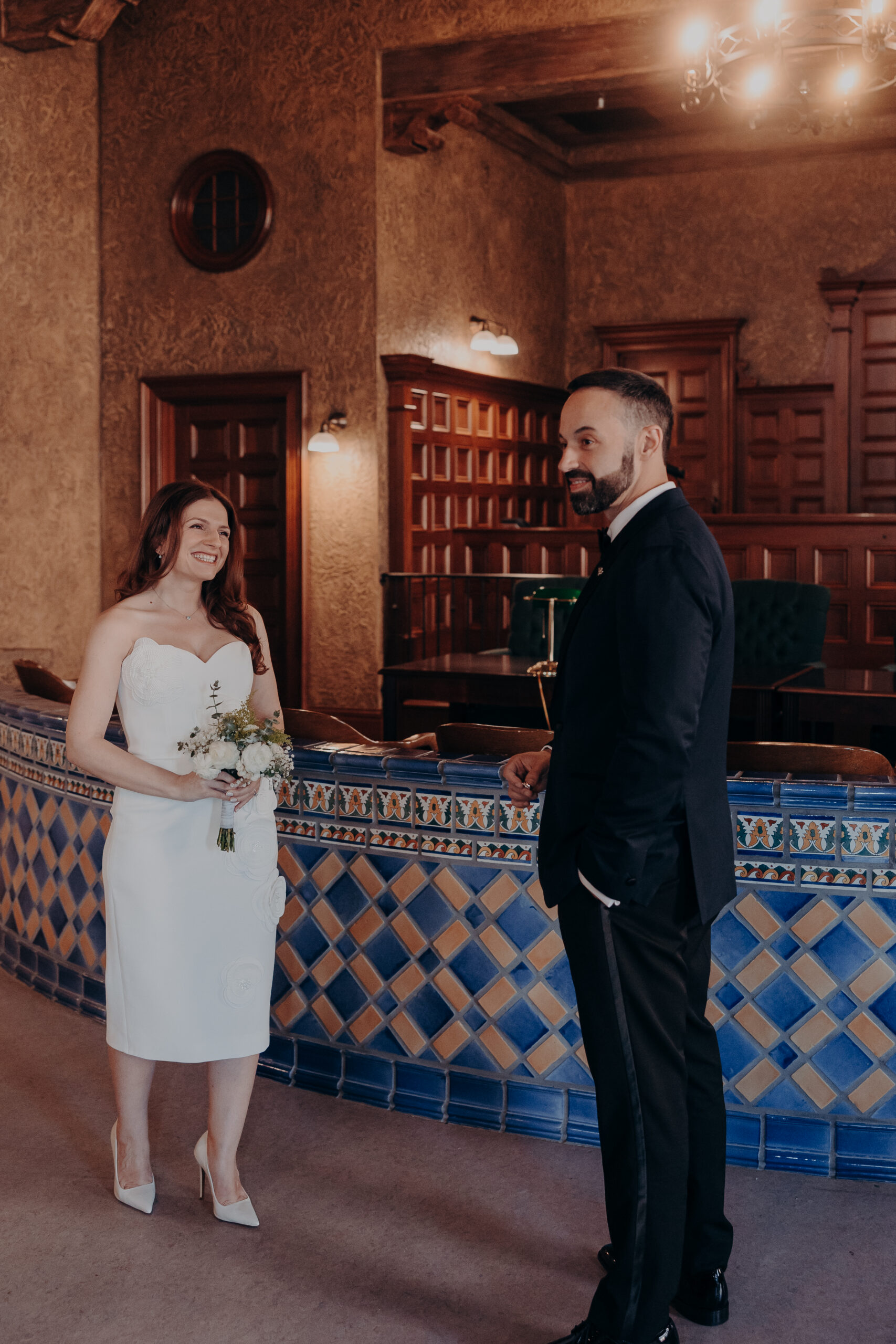 Couple laughing together inside the historic courthouse room with chandelier at their Sarasota FL courthouse wedding