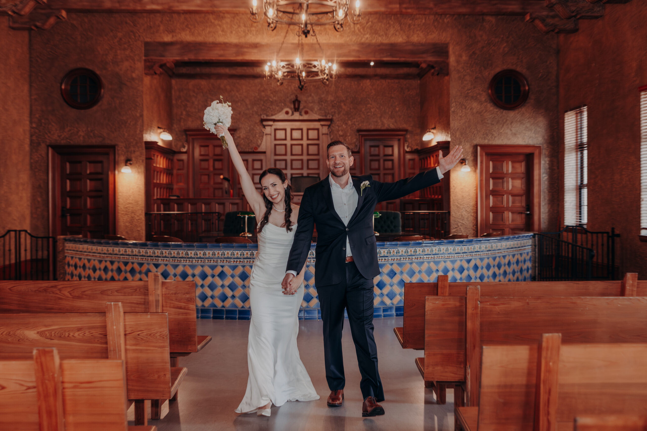 Liza and Will kissing against the ornate iron gate of the Historic Sarasota County Courthouse