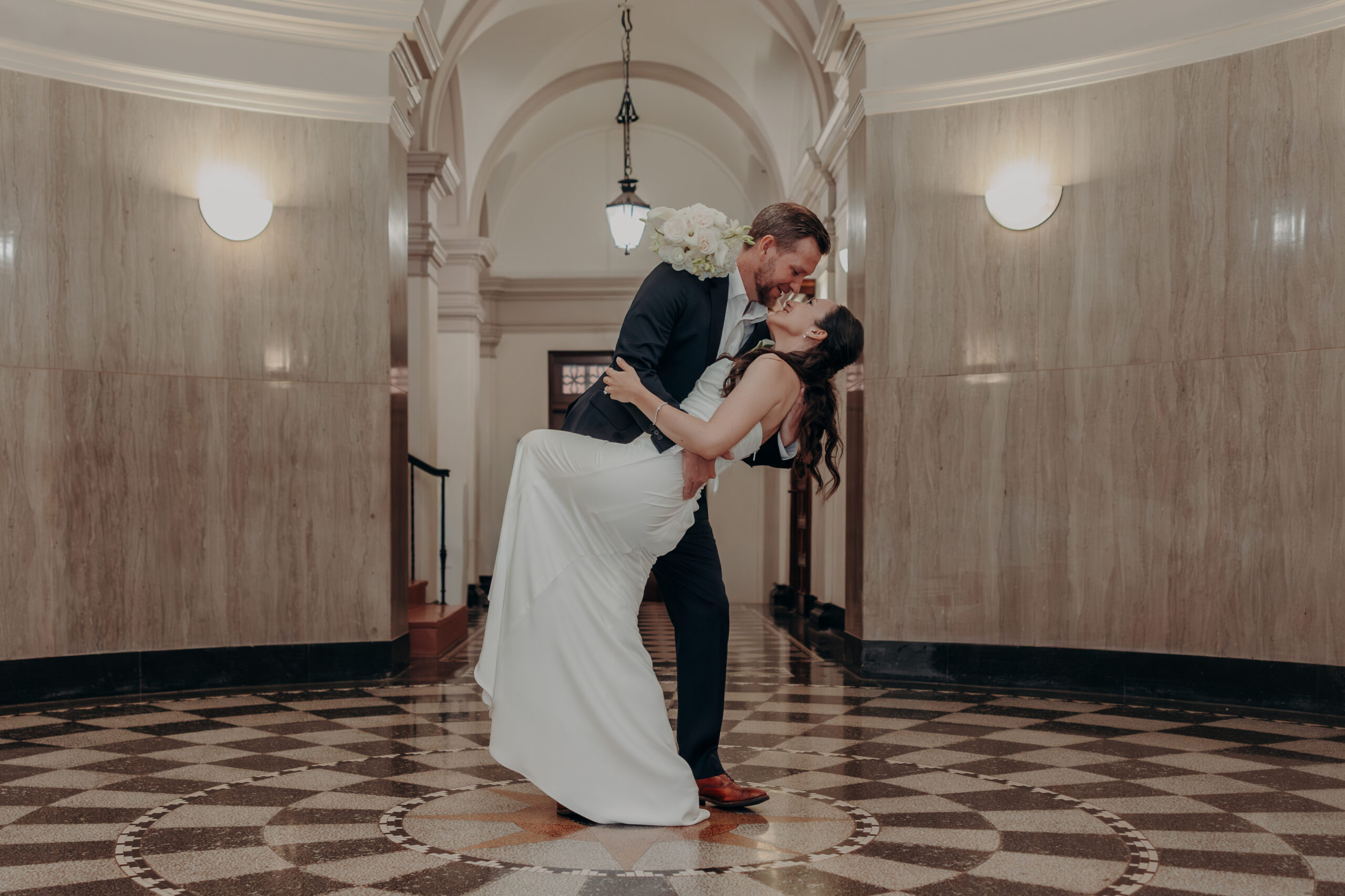 Liza and Will walking arm in arm toward the ornate archway at the Sarasota courthouse