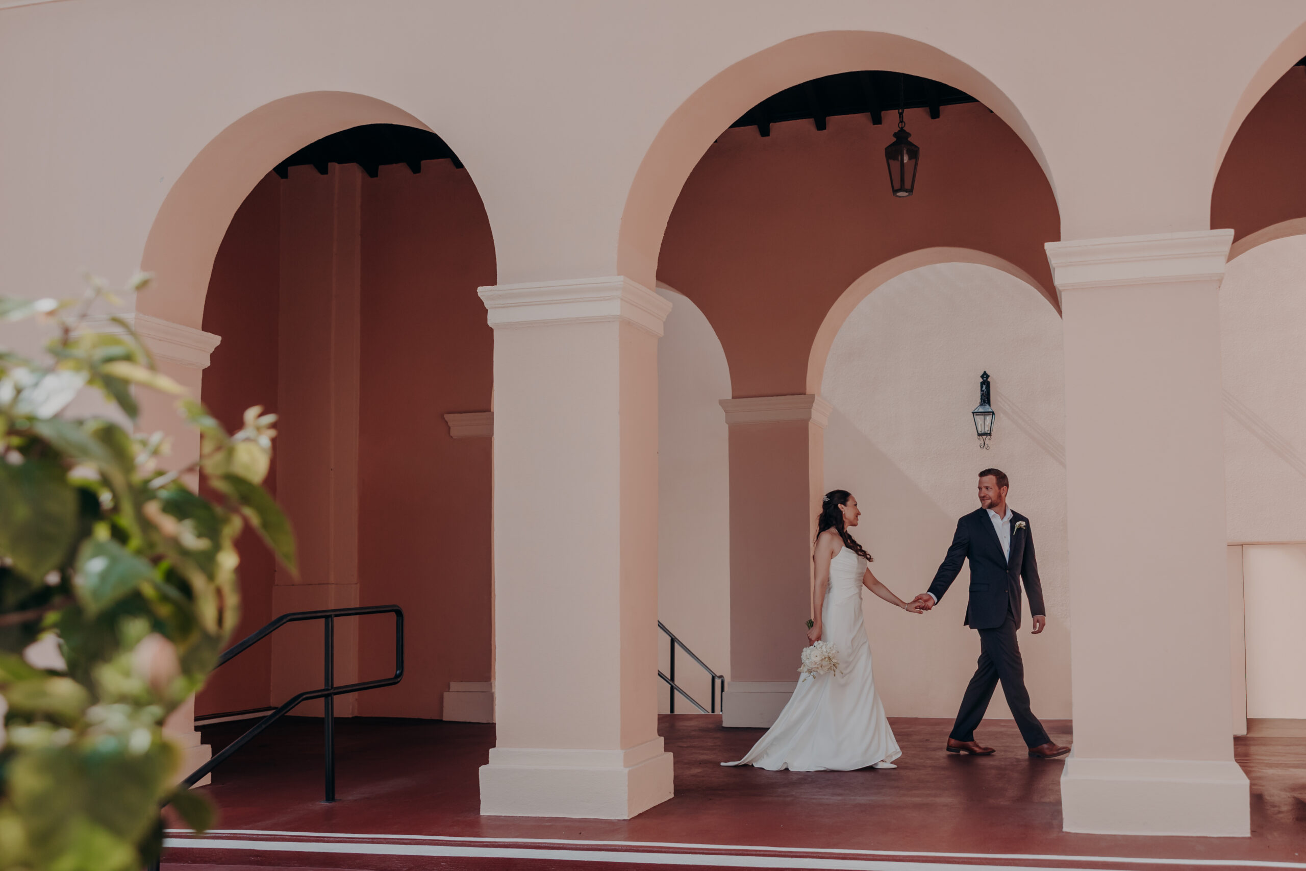 Liza and Will with huge smiles walking through the Sarasota courthouse grounds after their ceremony