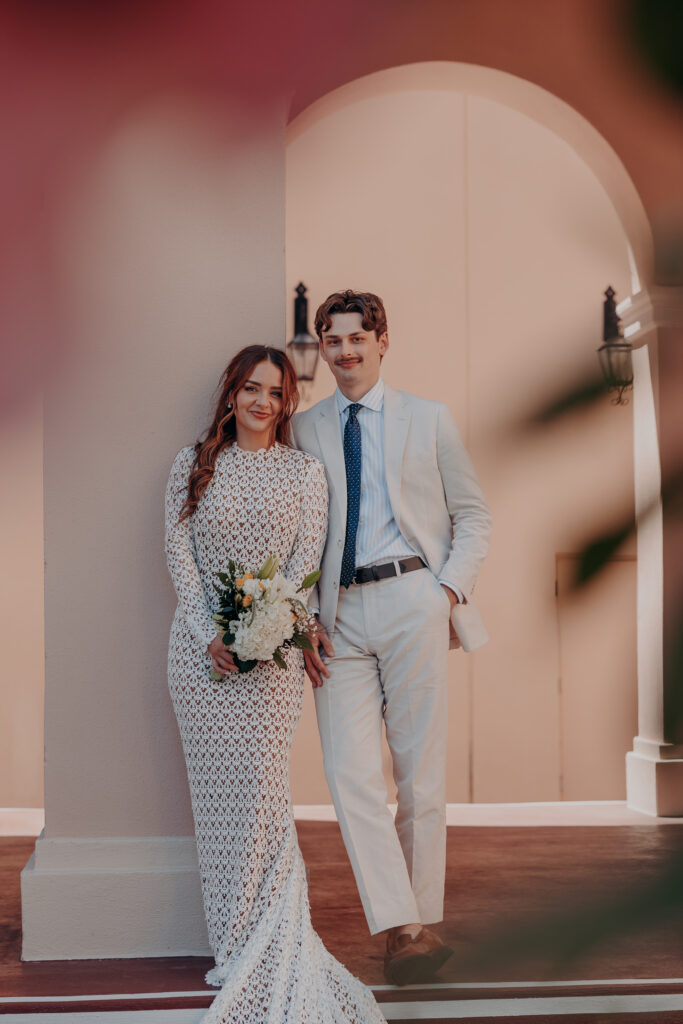 Mikaely and Chris smiling together framed by the exterior arch at the Historic Sarasota County Courthouse Sarasota Florida elopement