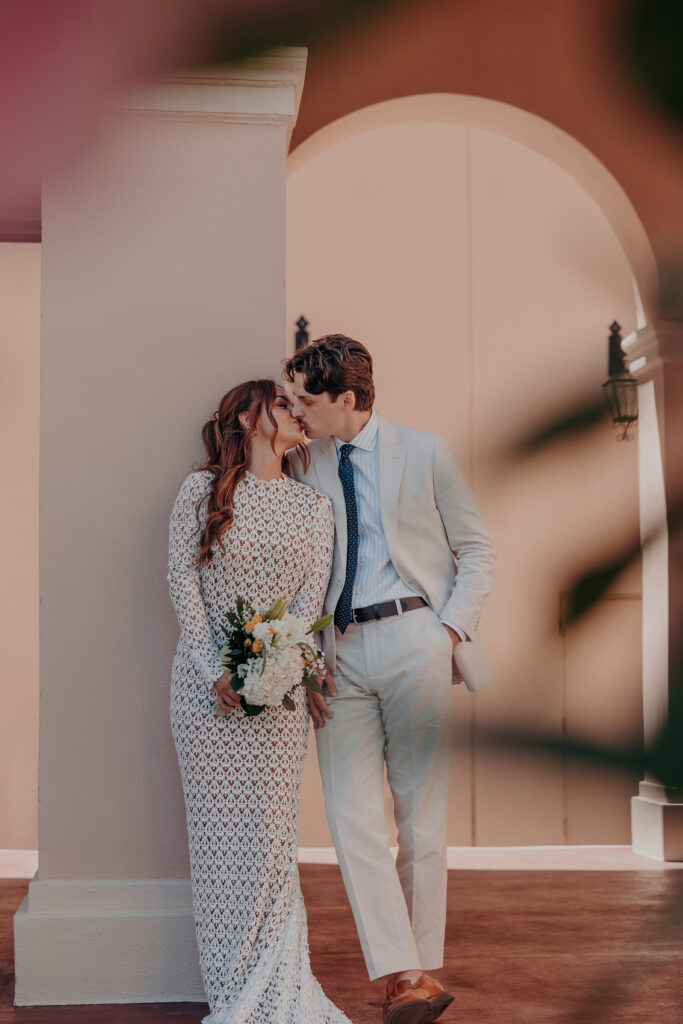 Mikaely and Chris kissing beneath the arched stone entrance of the Historic Sarasota County Courthouse in Sarasota FL