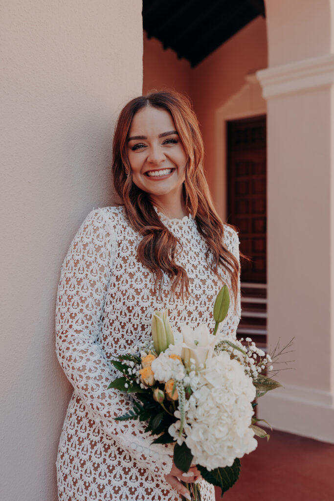 Mikaely beaming and laughing outdoors against the courtyard of the Historic Sarasota County Courthouse during her elopement in Sarasota Florida