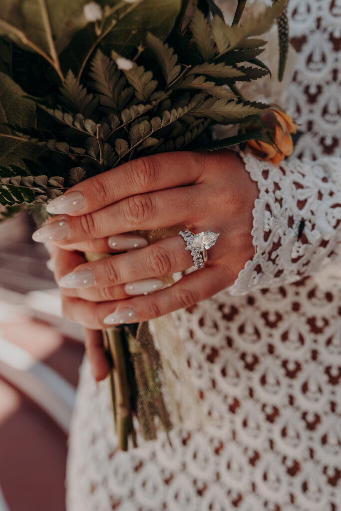 Close detail of Mikaelys white wedding bouquet with fern greenery at her Sarasota courthouse elopement