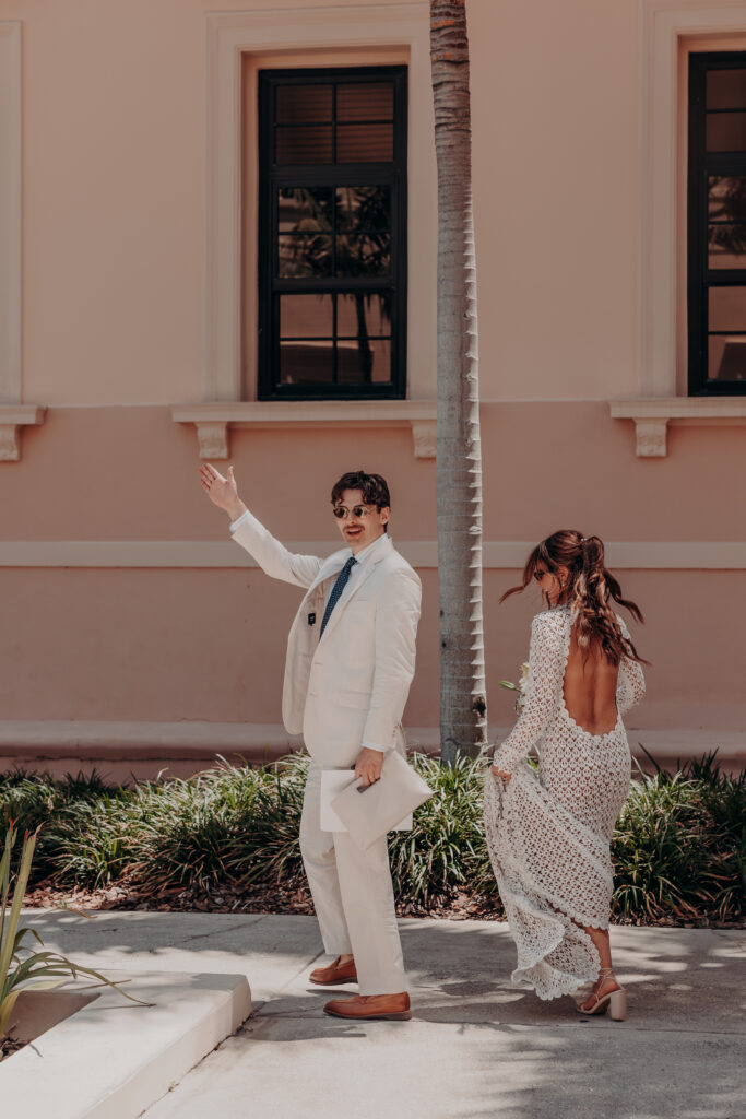 Mikaely and Chris posed beside a palm tree against the exterior wall of the Historic Sarasota County Courthouse in Sarasota FL