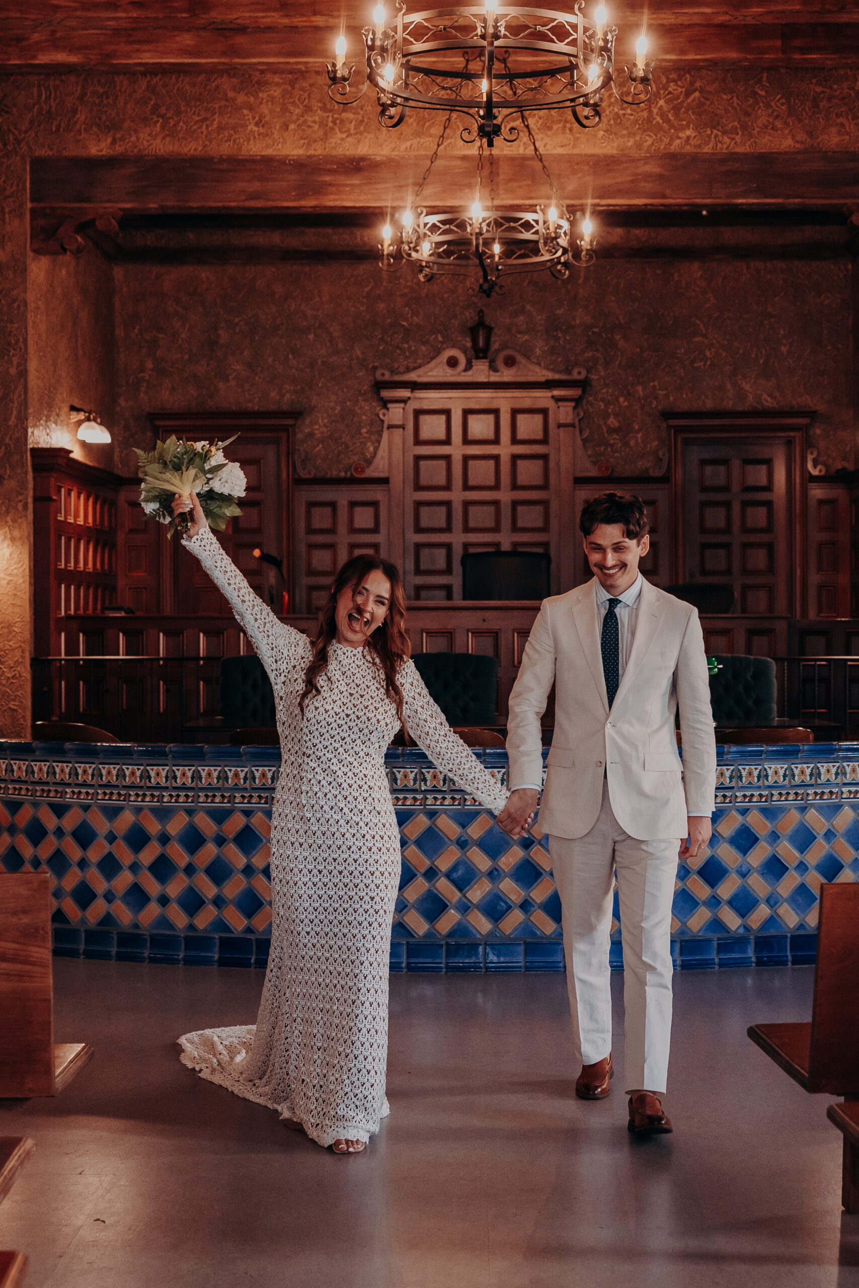 Wide angle of the ceremony room with ornate iron chandeliers at the Historic Sarasota County Courthouse during Mikaely and Chris elopement in Sarasota FL