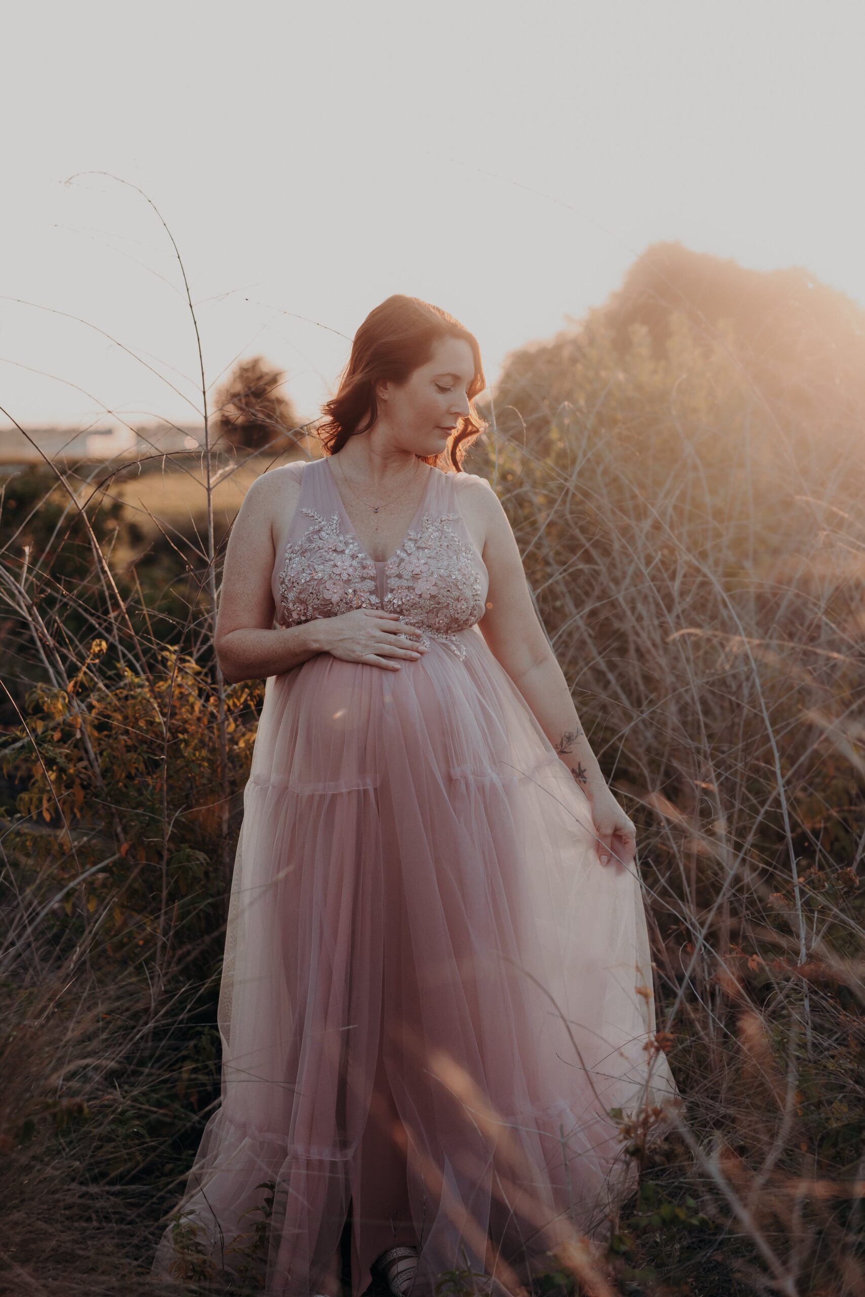 Sarasota maternity photographer captures glowing mother in pink tulle gown at golden hour at the Celery Fields