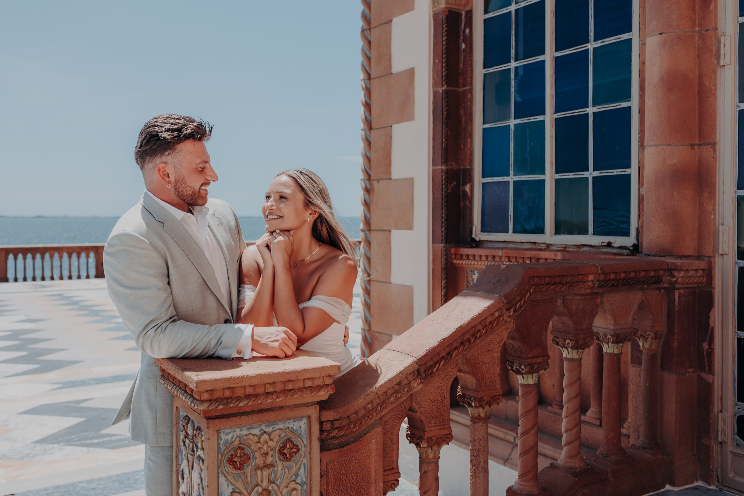 Nicole and Gabe walking through the arched loggia at the Ringling Museum Sarasota Florida engagement