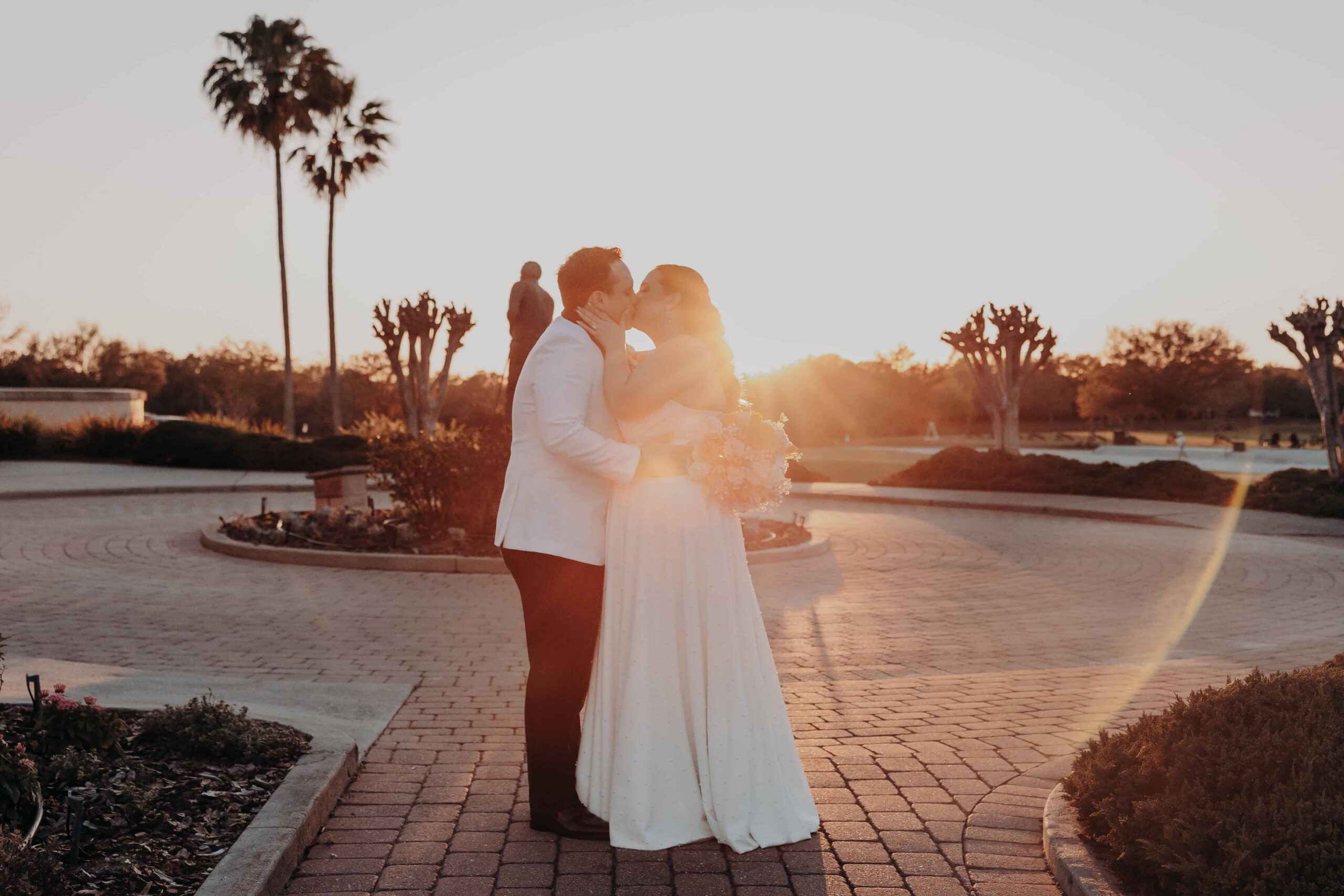 Bride and groom sharing golden hour kiss on the stone courtyard at Lakewood Ranch Golf and Country Club wedding in Sarasota FL