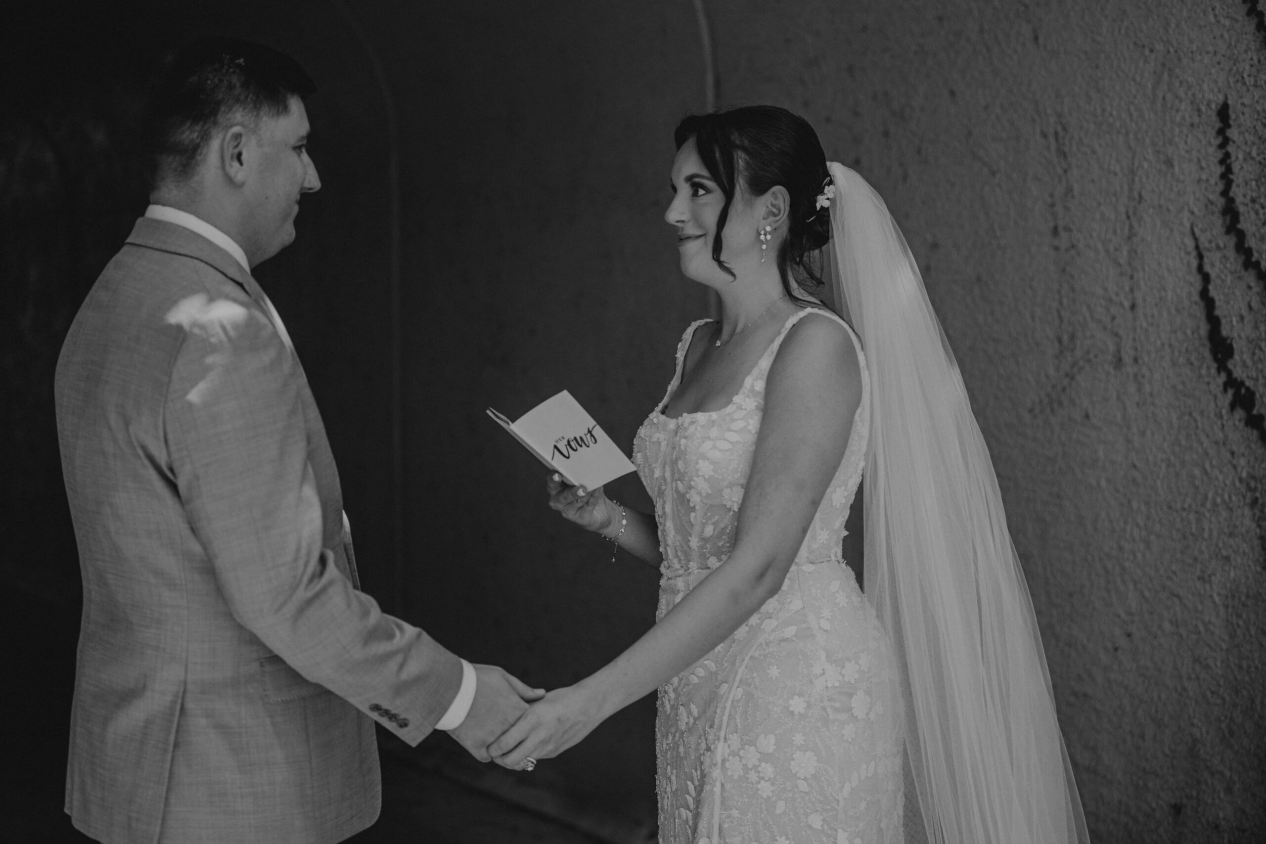 Black and white photo of Brianna and Ryan exchanging private vows in the ivy-covered tunnel at Lakewood Ranch Golf and Country Club