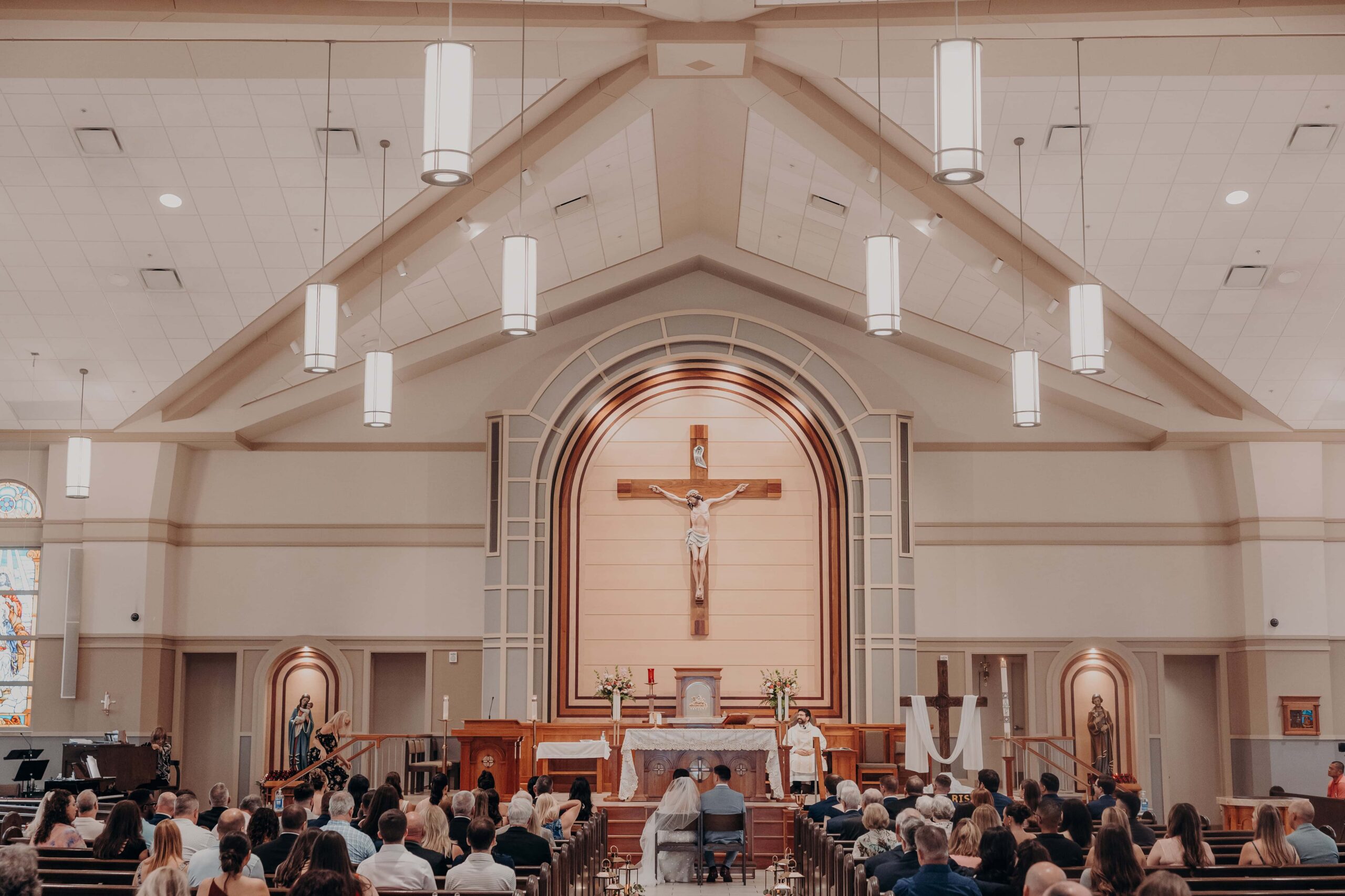 Brianna and Ryan exchanging vows at the altar of Our Lady of the Angels Catholic Church in Lakewood Ranch Florida