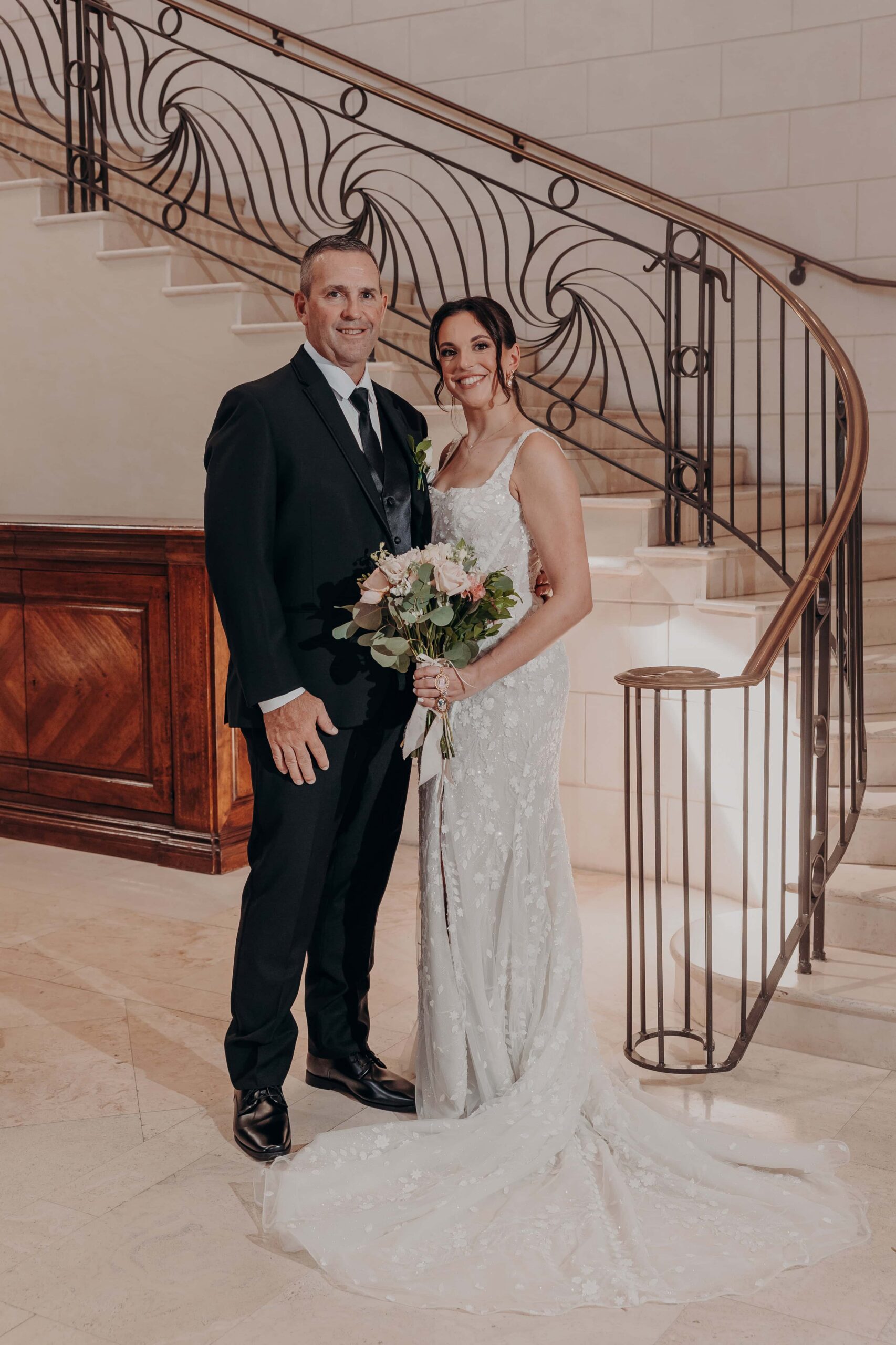 Brianna with her father on the ornate grand staircase at Lakewood Ranch Golf and Country Club on her wedding day