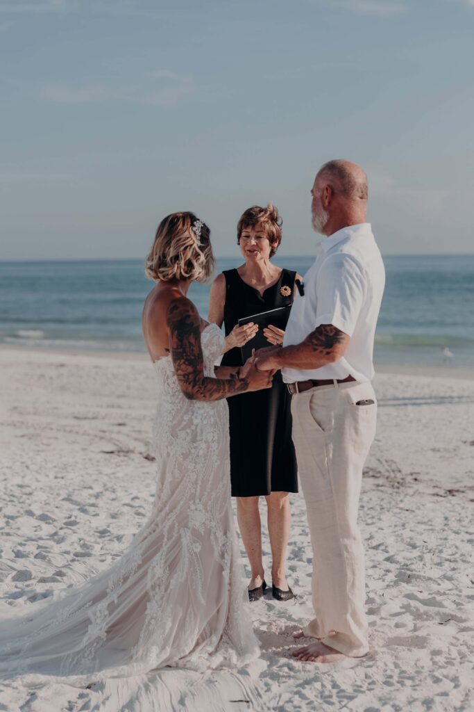 Bride and groom holding each other on Siesta Key beach after eloping in Sarasota