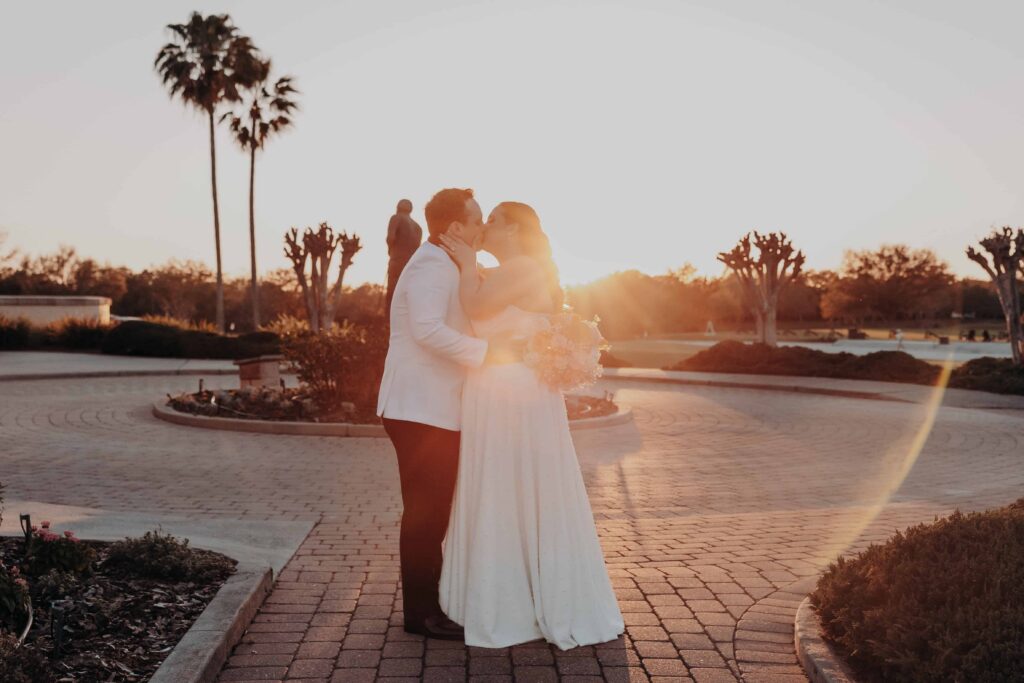 Bride and groom sharing golden hour kiss on stone courtyard at Lakewood Ranch Golf and Country Club Sarasota FL