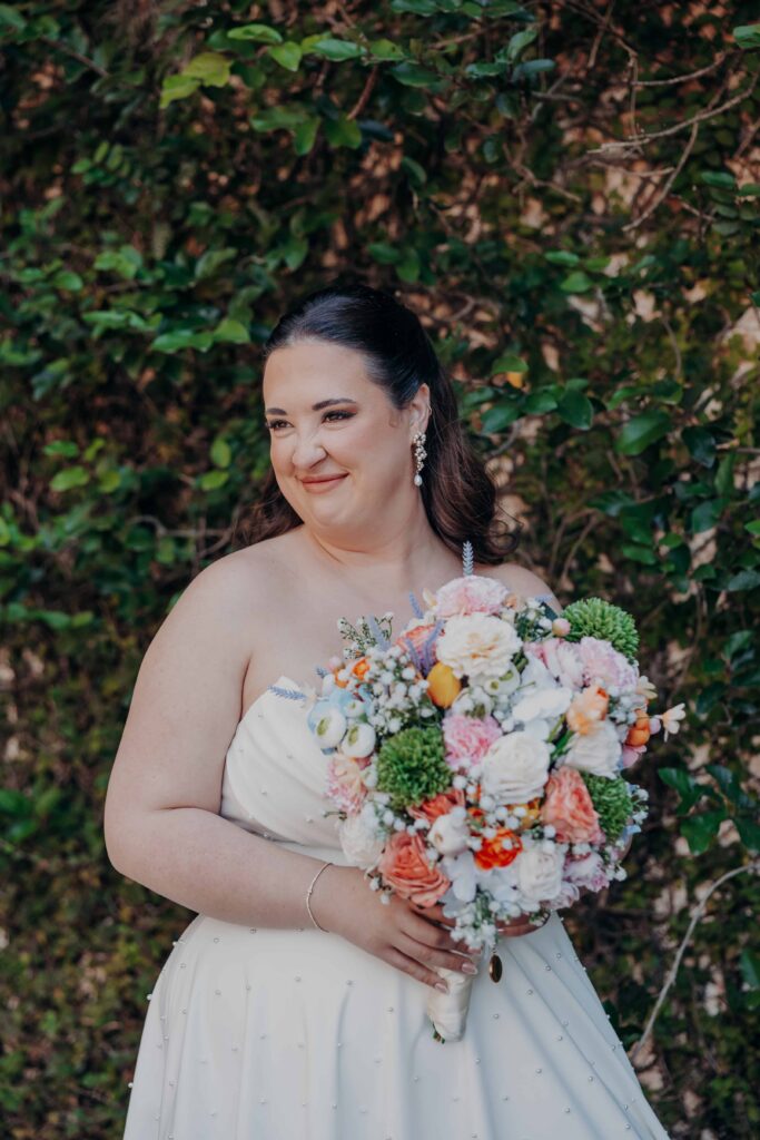 Bride holding colorful DIY wildflower bouquet of peach roses ranunculus and hydrangeas - Lakewood Ranch wedding