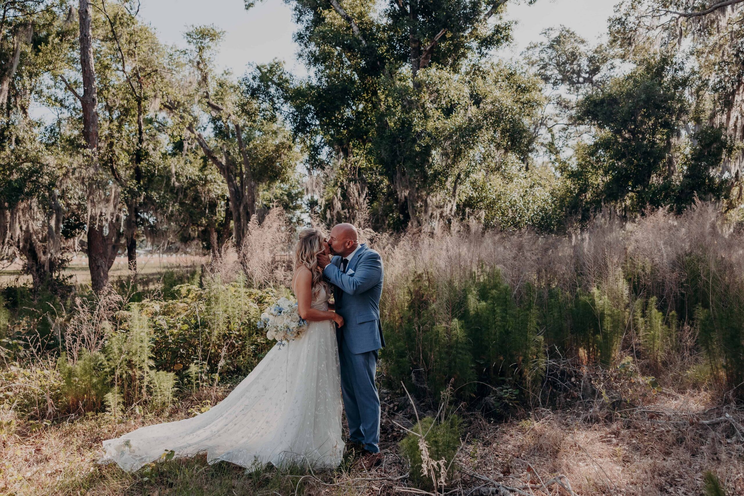 Bride and groom sharing a kiss in the Spanish moss meadow at Browns Grove Farm Parrish Florida