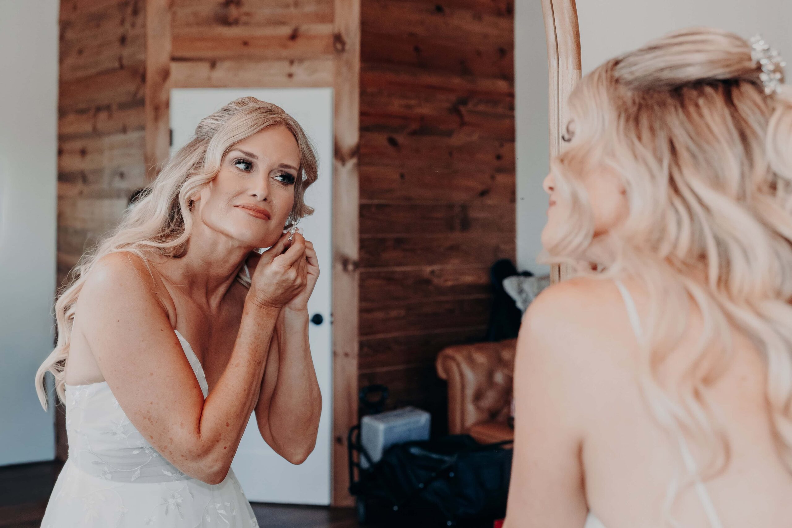 Bride getting ready earrings in mirror at Brown's Grove Farm wedding Parrish Florida