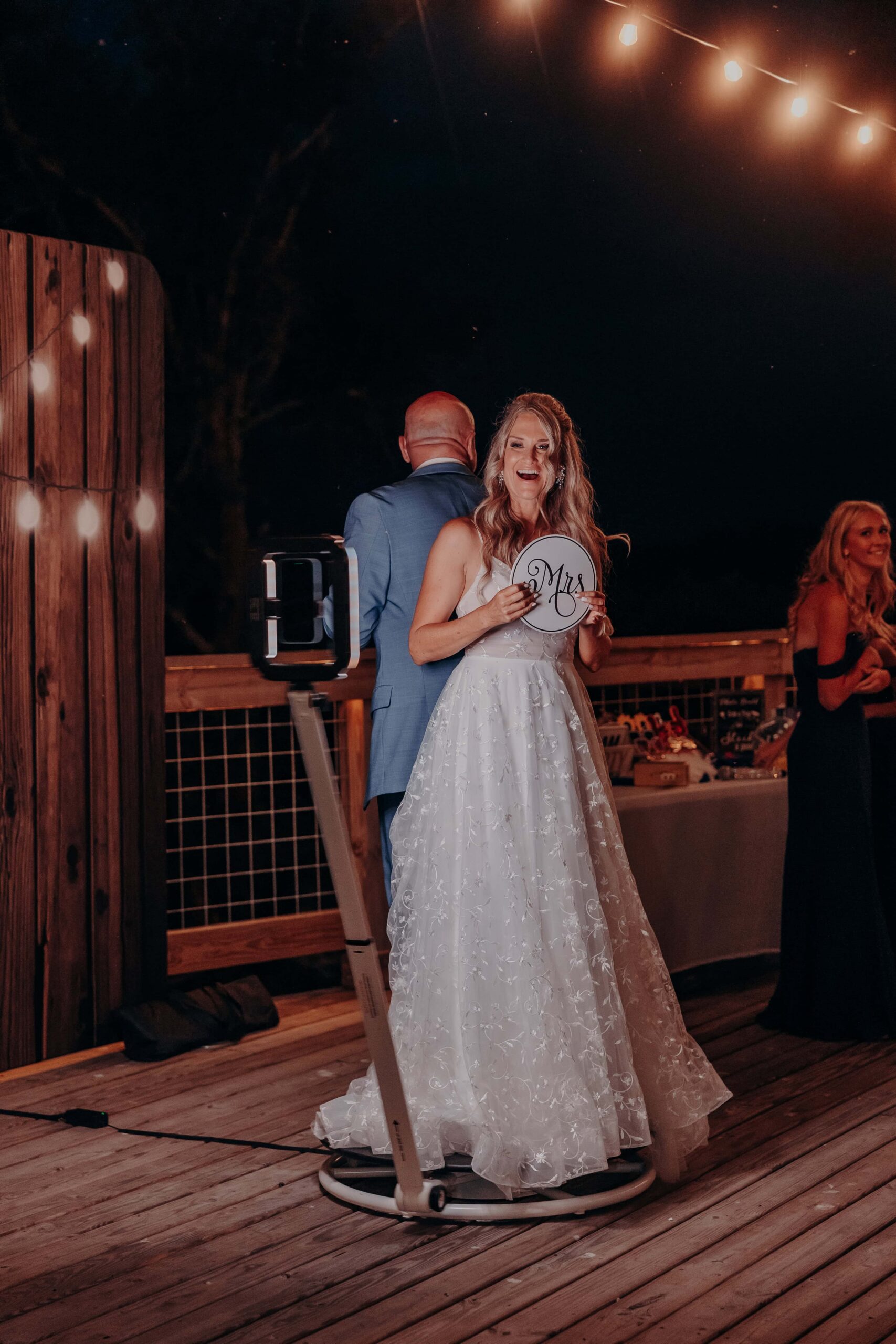 Bride on 360 photo booth holding Mrs sign at Brown's Grove Farm wedding reception
