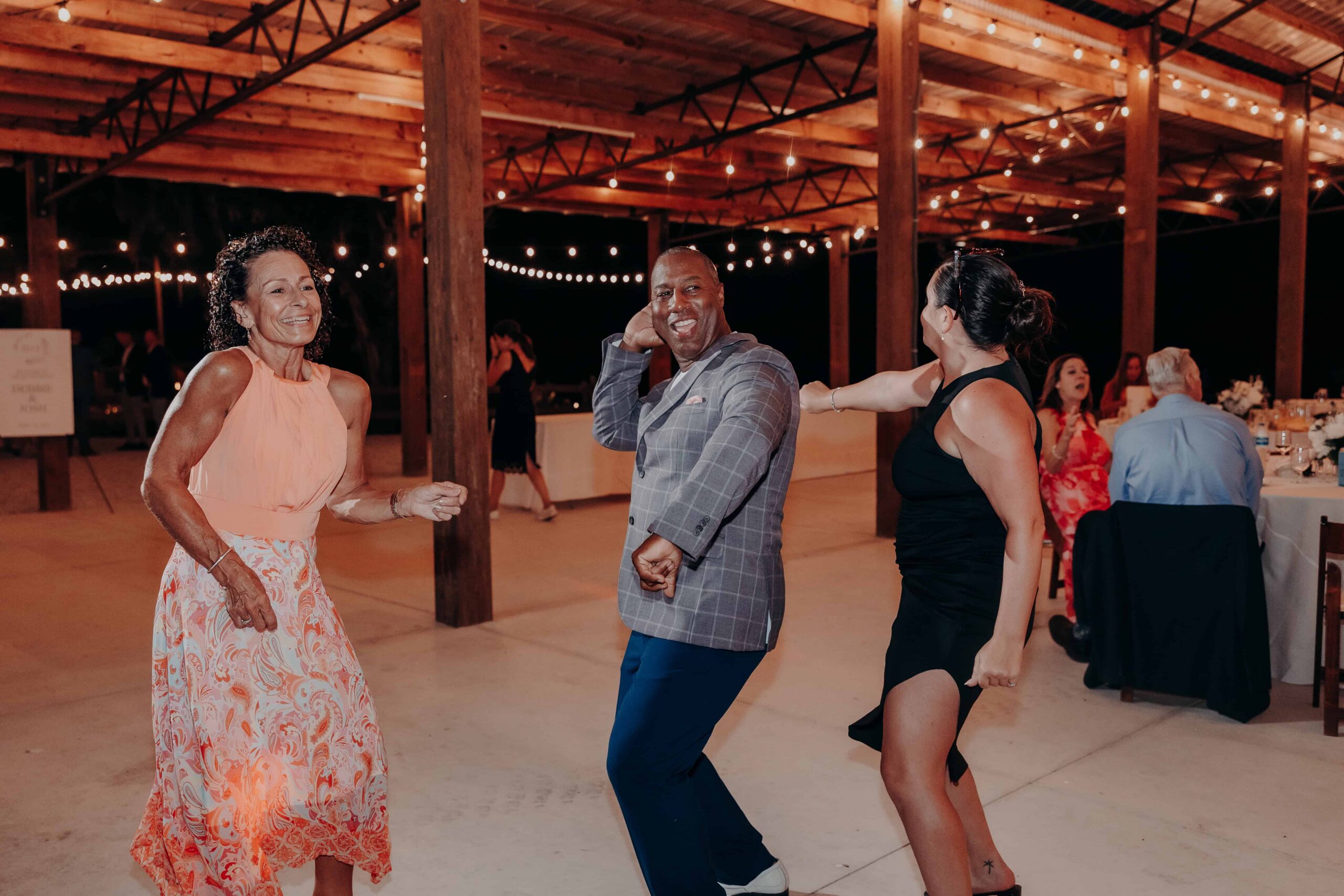 Wedding guests dancing on open air pavilion dance floor at night at Brown's Grove Farm reception