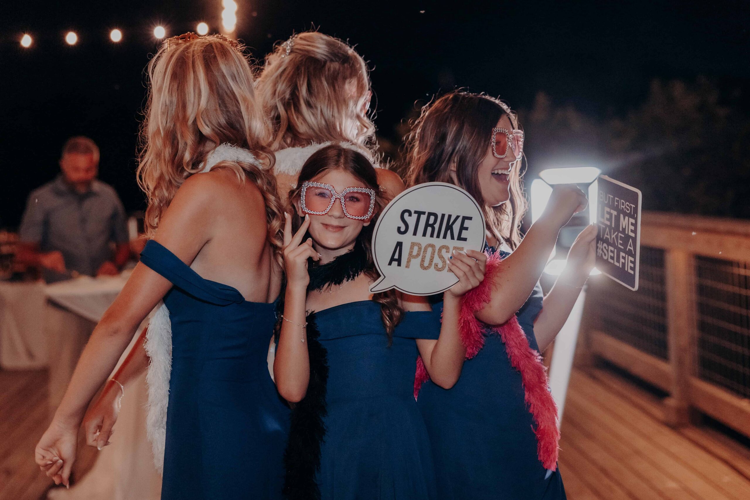 Bride Debbie and all three daughters with photo booth props at Brown's Grove Farm wedding reception