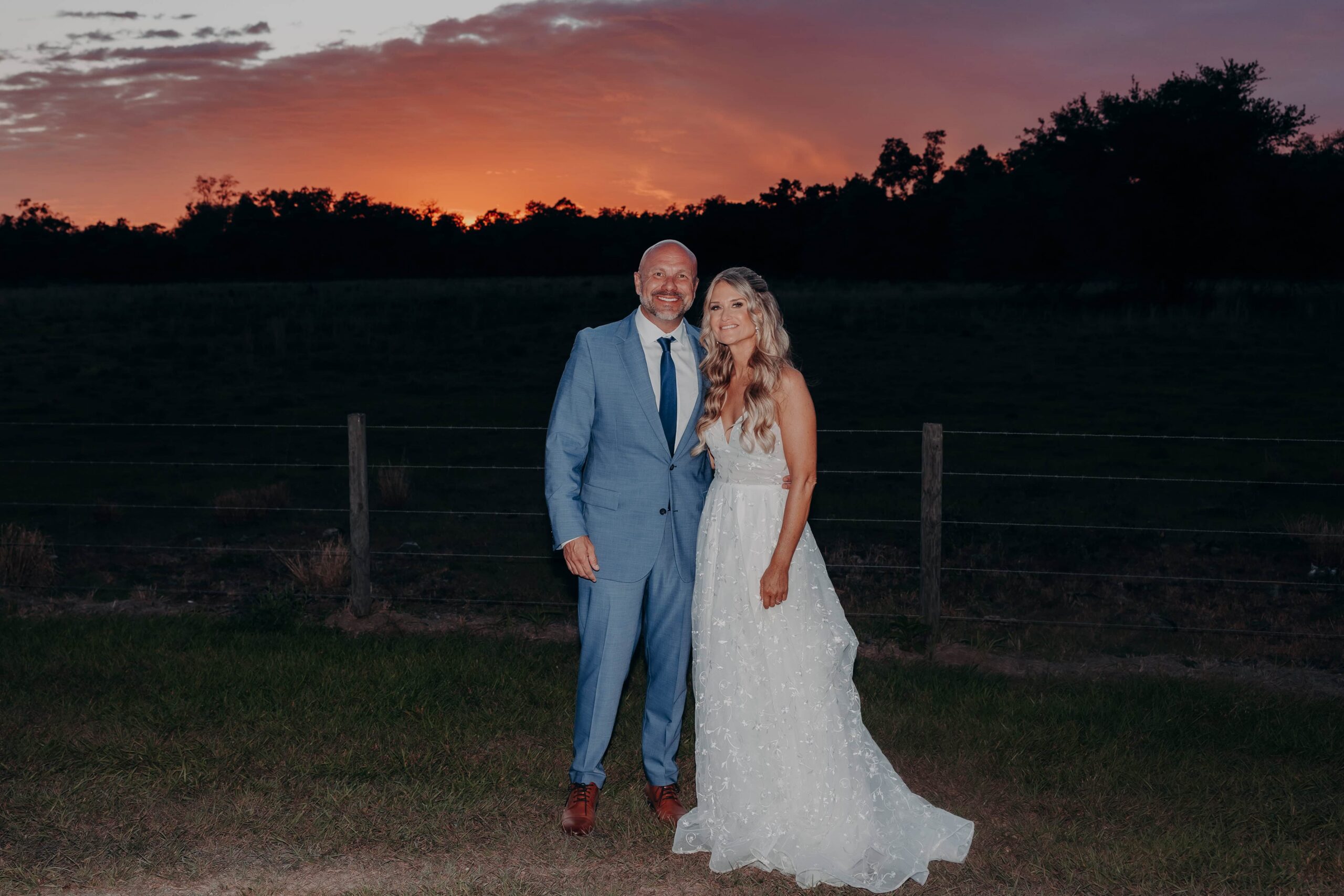 Bride and groom sunset portrait at fence line at Brown's Grove Farm wedding Parrish Florida