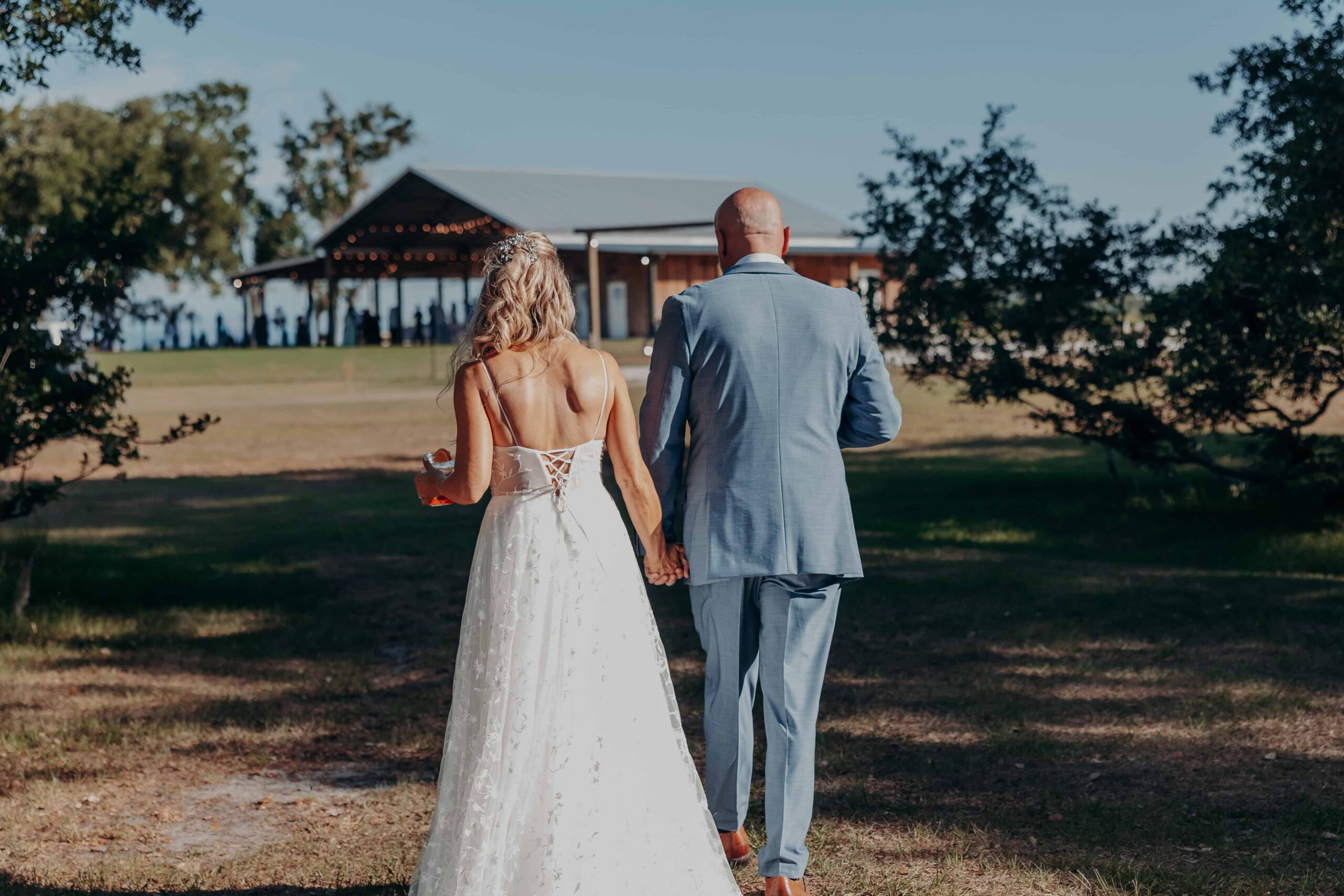 Bride and groom walking toward barn at Brown's Grove Farm wedding venue Parrish Florida