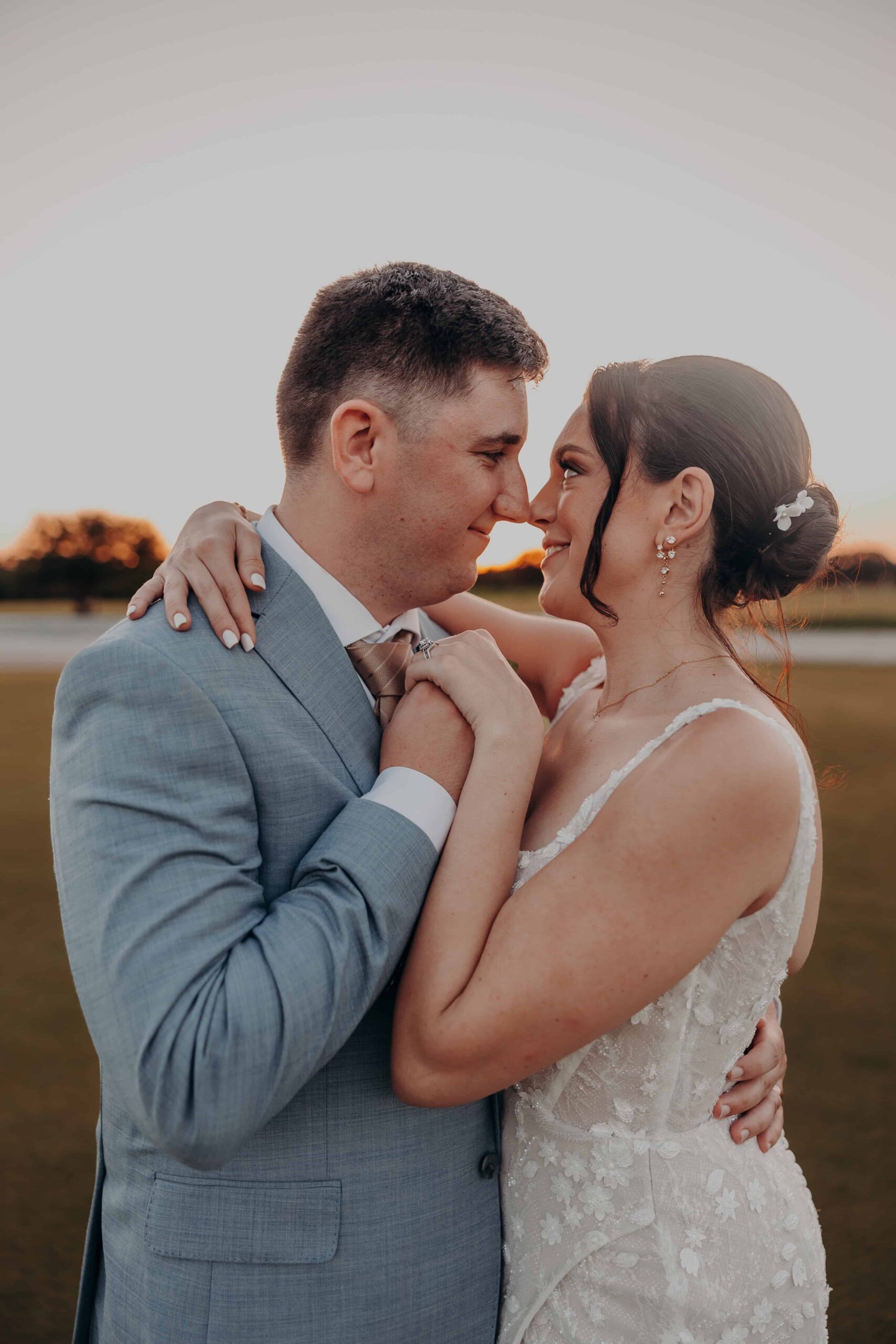 Couple portrait at golden hour with orange and gold sky over the water at Lakewood Ranch Golf and Country Club photographed by Angela Moon Photography Sarasota