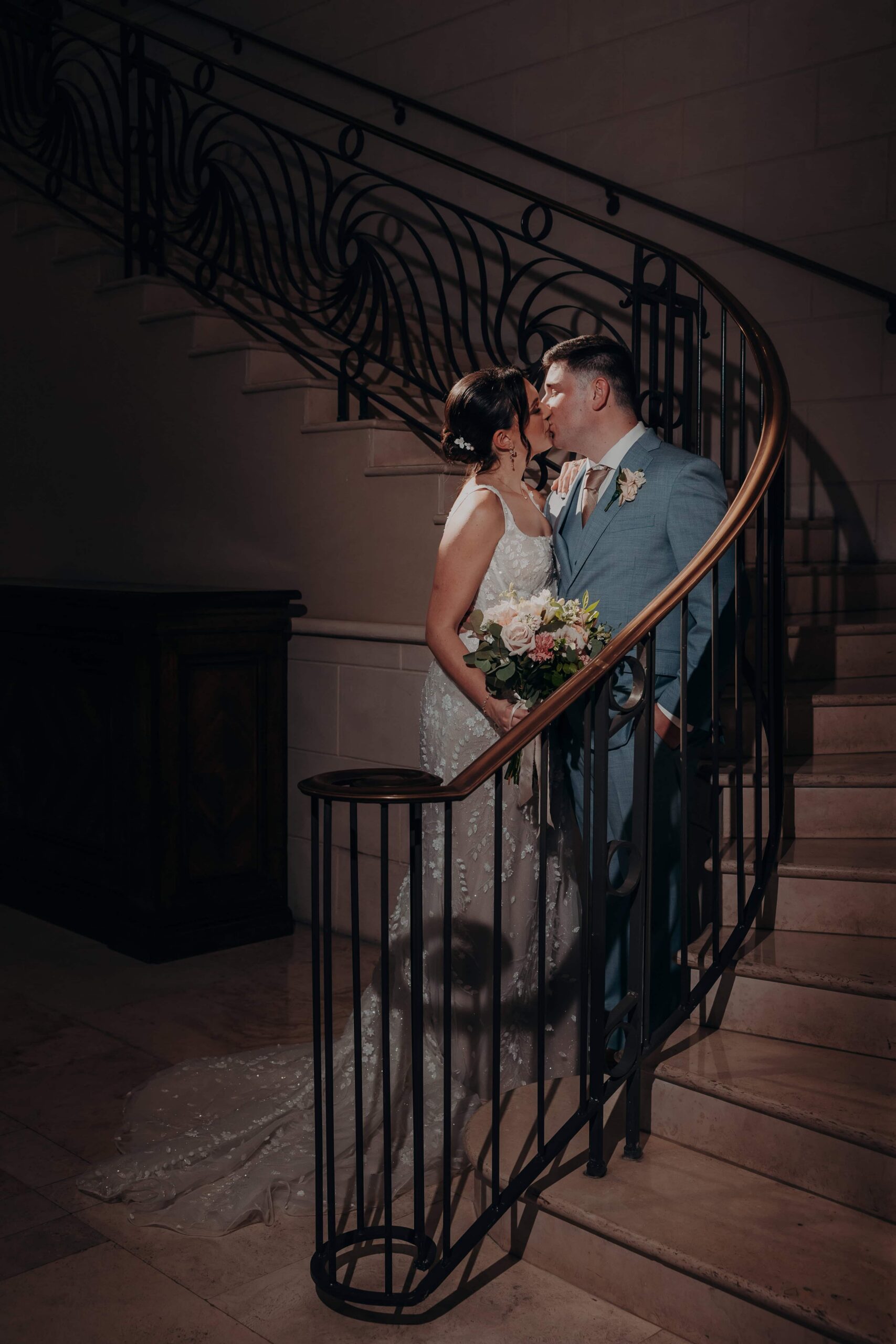 Couple portrait of Brianna and Ryan Whitley at the base of the grand staircase at Lakewood Ranch Golf and Country Club