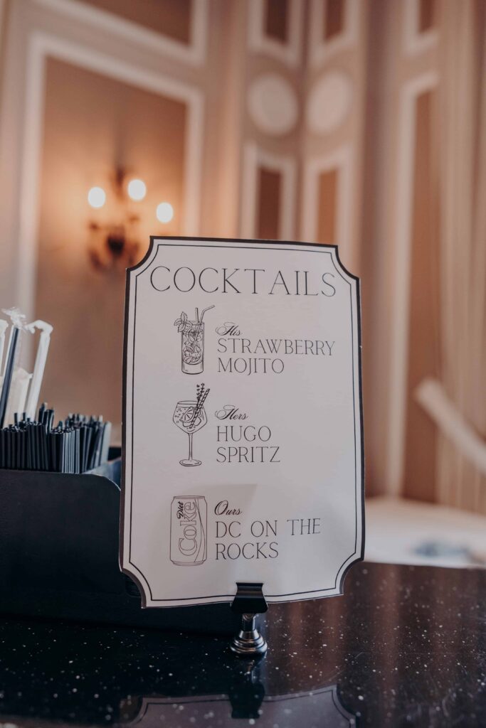 Custom cocktail menu sign His Strawberry Mojito Hers Hugo Spritz Ours DC on the Rocks at wedding reception