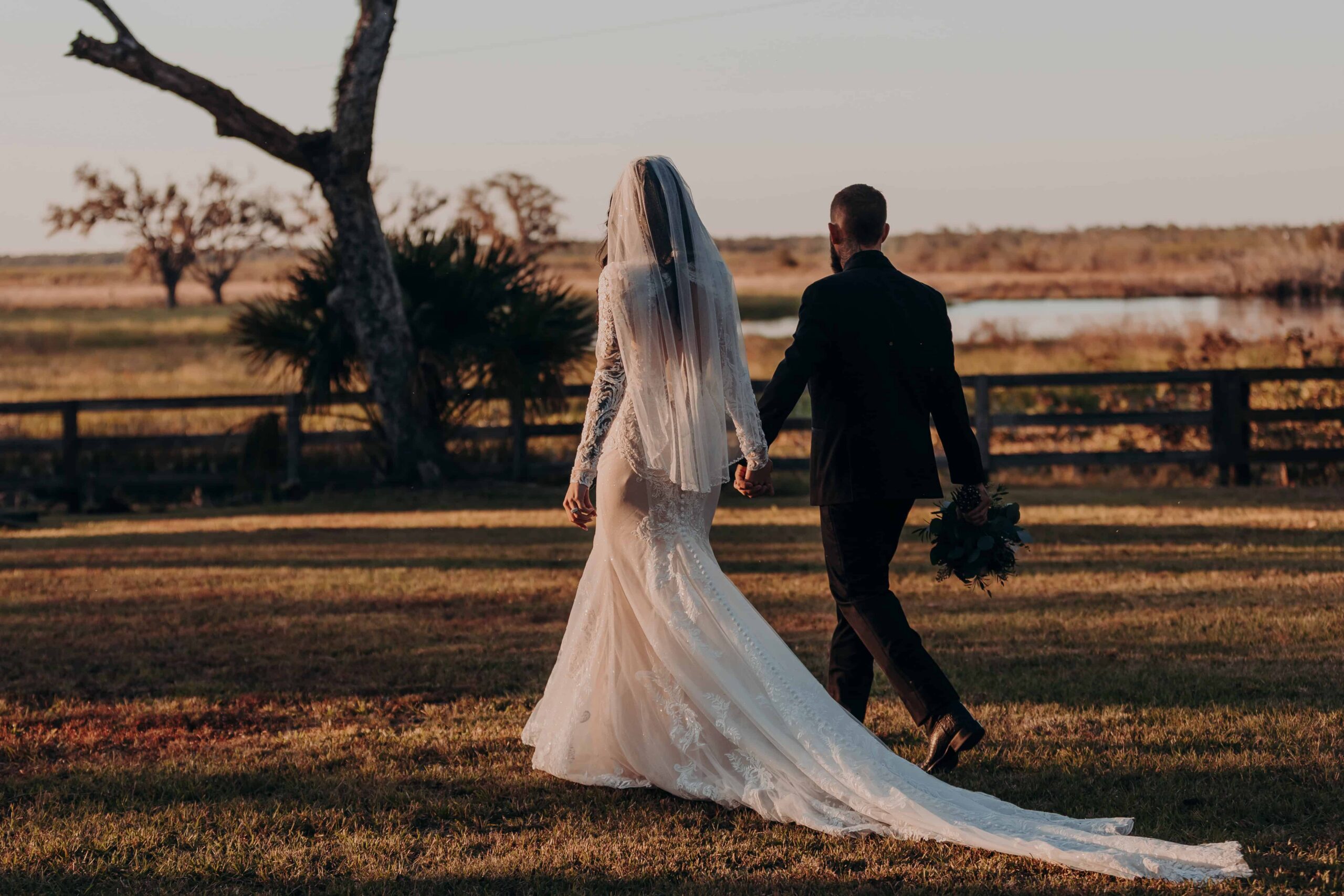 Bride and groom walking toward the golden hour pasture at Diamond C Ranch Myakka City Florida