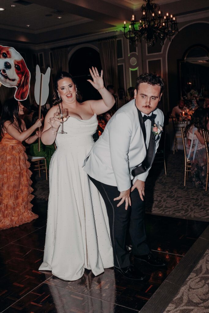 Groom dancing on packed dance floor with dog face cutout at Lakewood Ranch Golf and Country Club reception