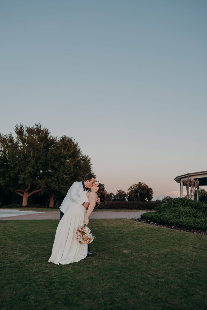 Groom dipping bride for a kiss at twilight on golf course at Lakewood Ranch Golf and Country Club