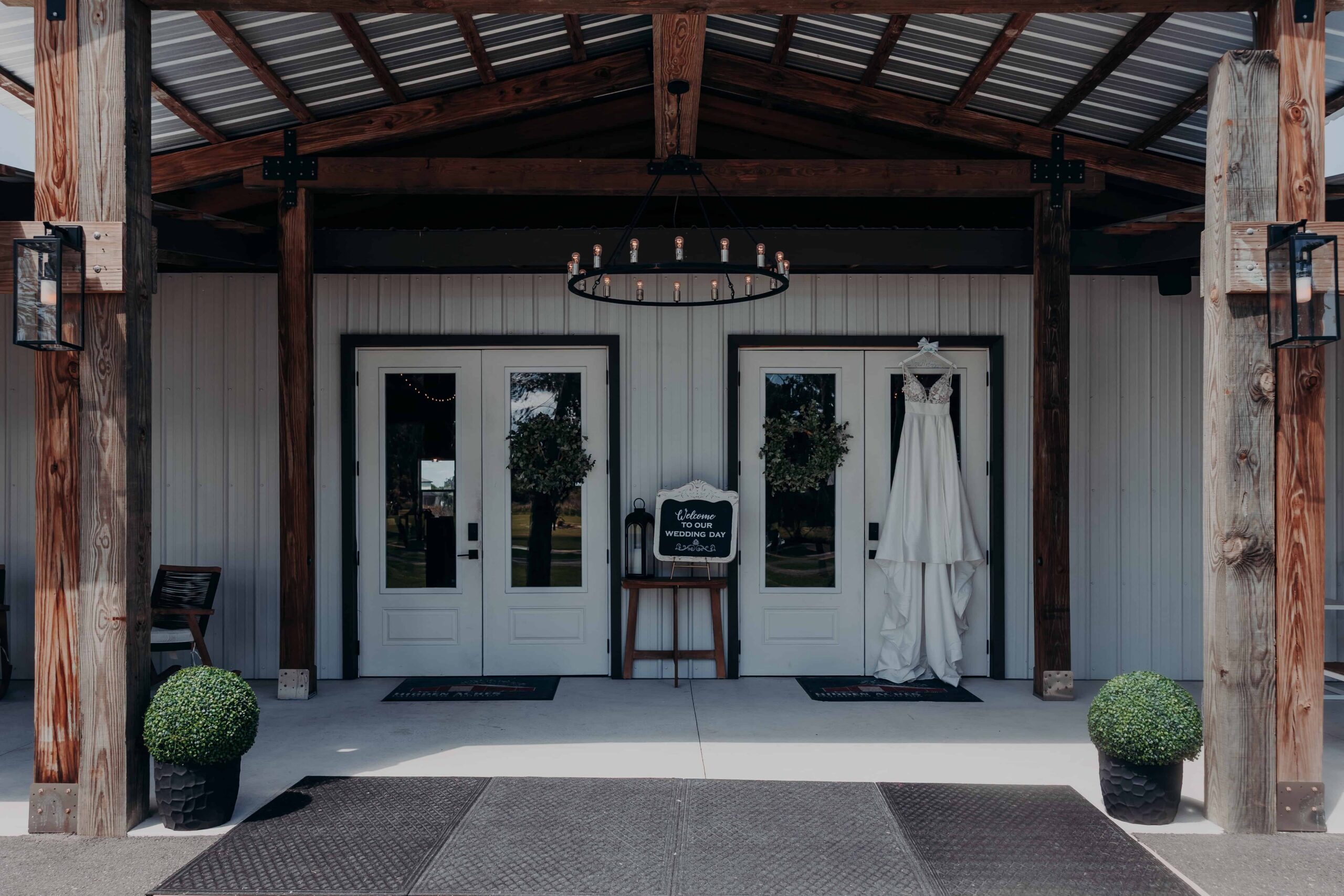 Hidden Acres venue entrance with wedding dress and welcome sign