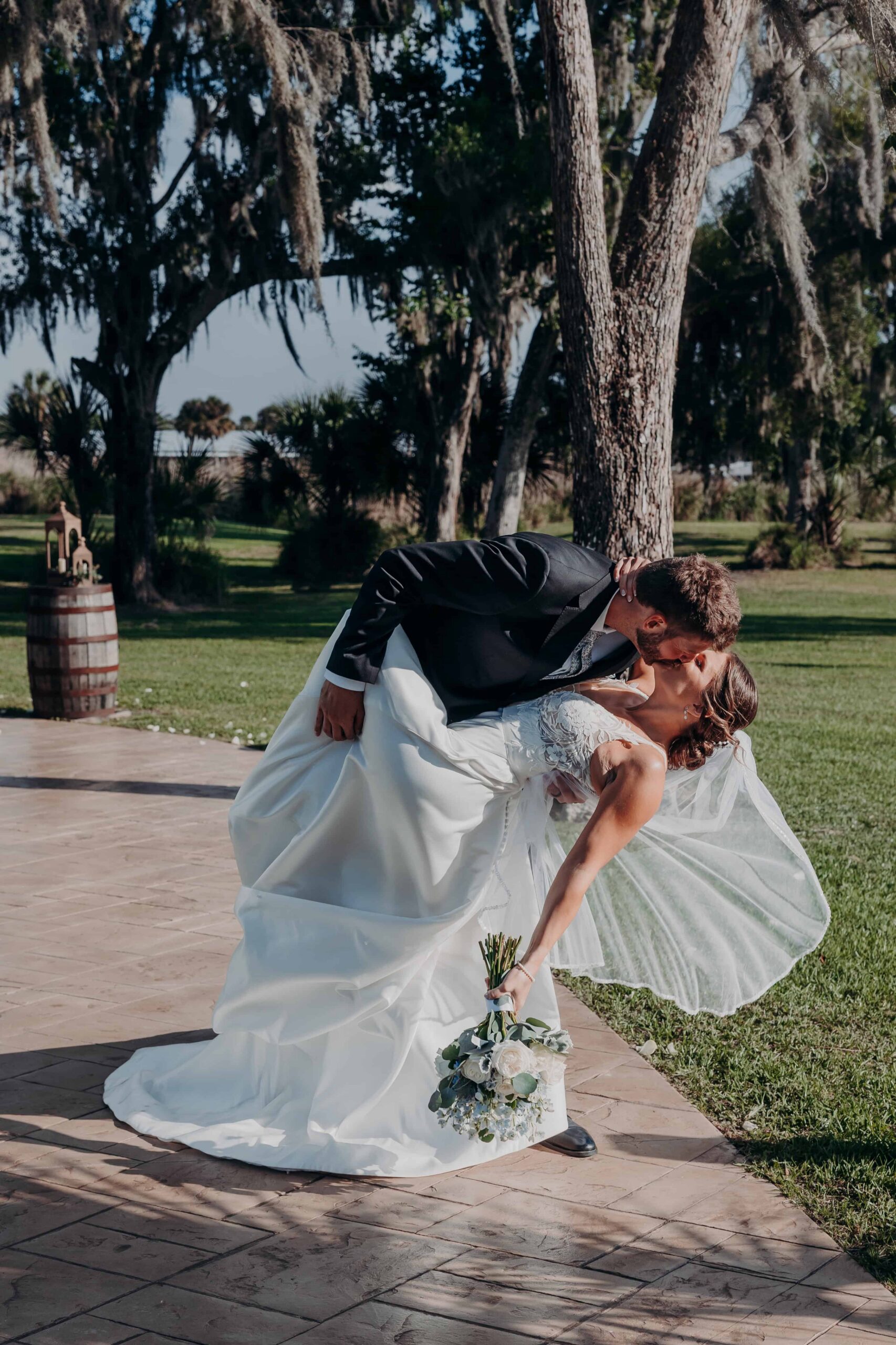 Hidden Acres wedding bride and groom dip kiss among Spanish moss trees