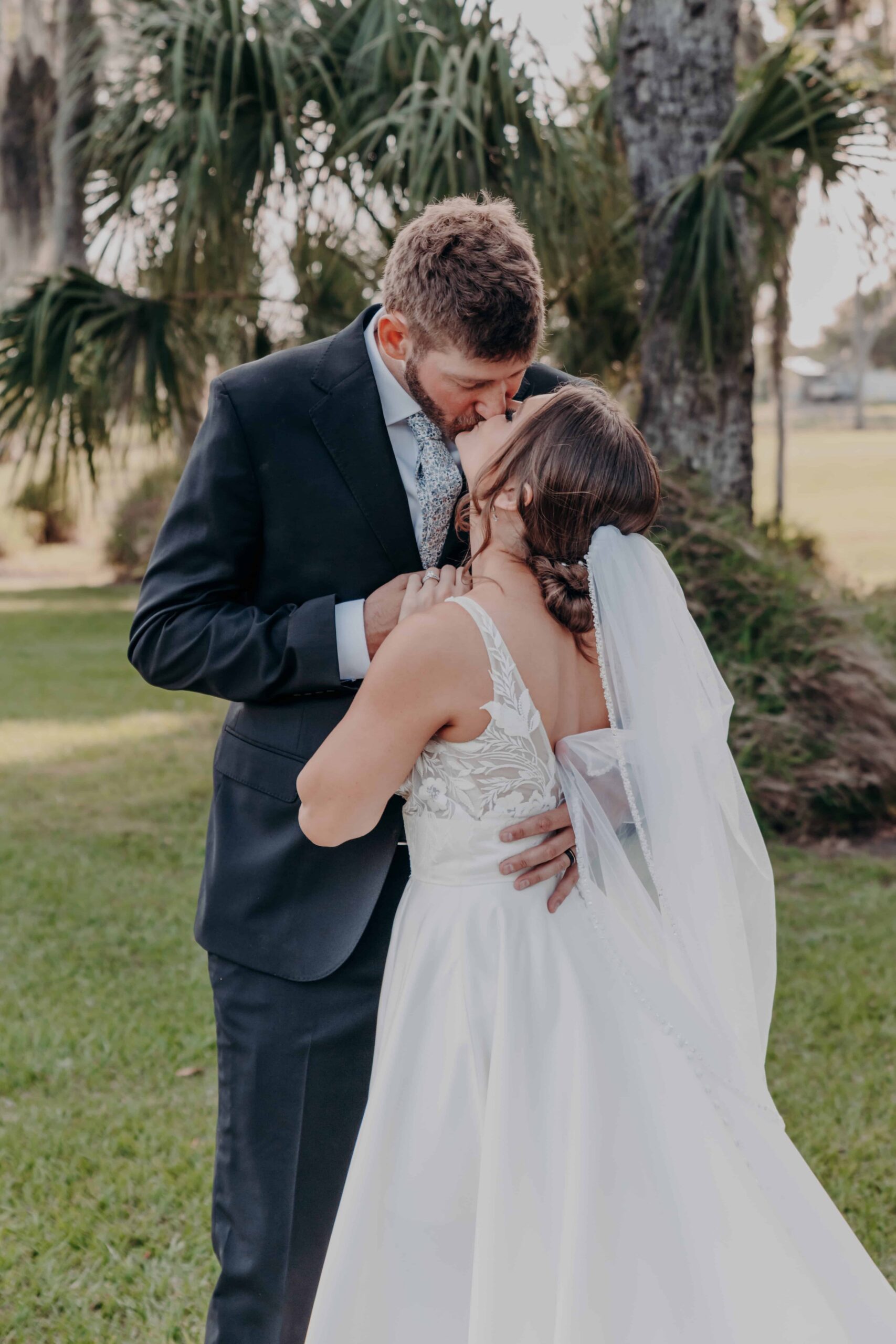 Hidden Acres wedding bride and groom portrait kiss among palm trees