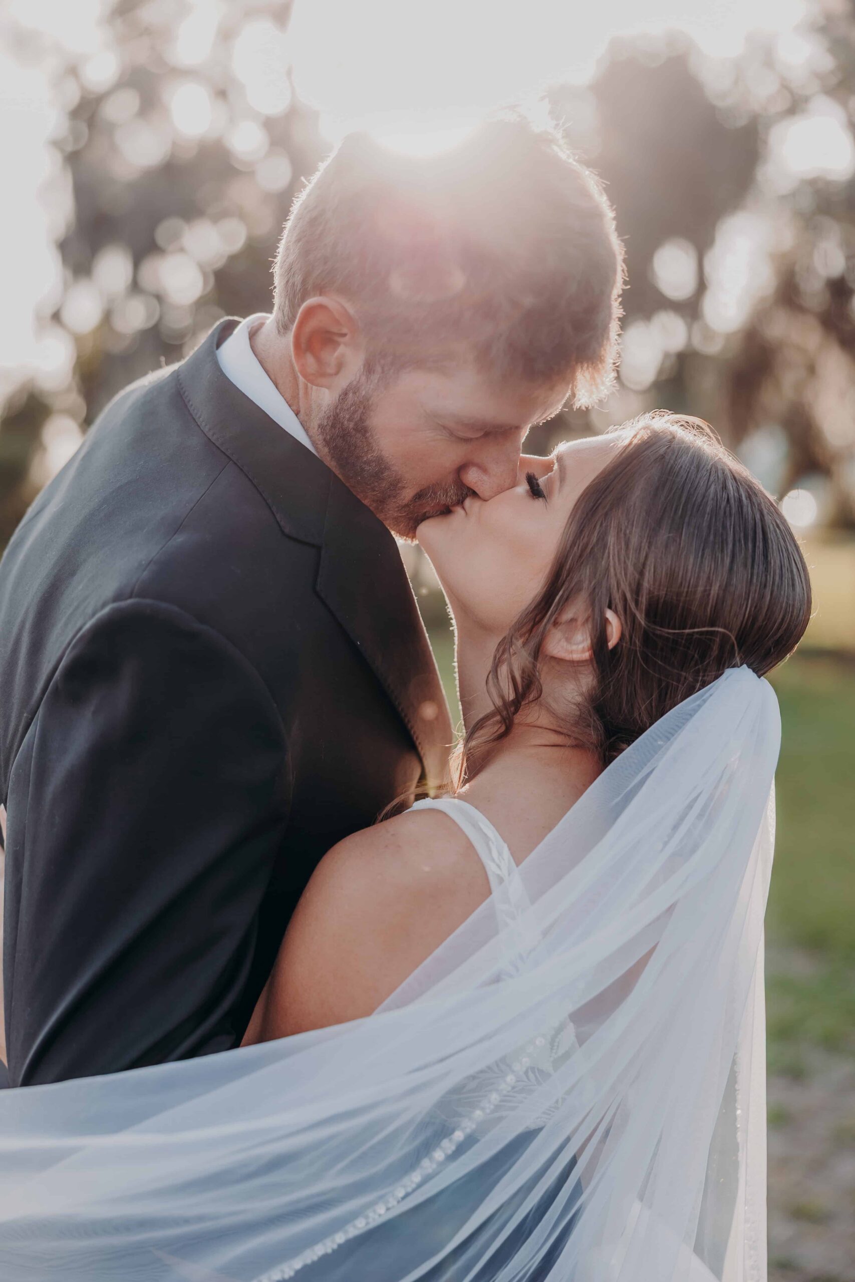 Hidden Acres wedding bride and groom veil kiss golden hour backlight