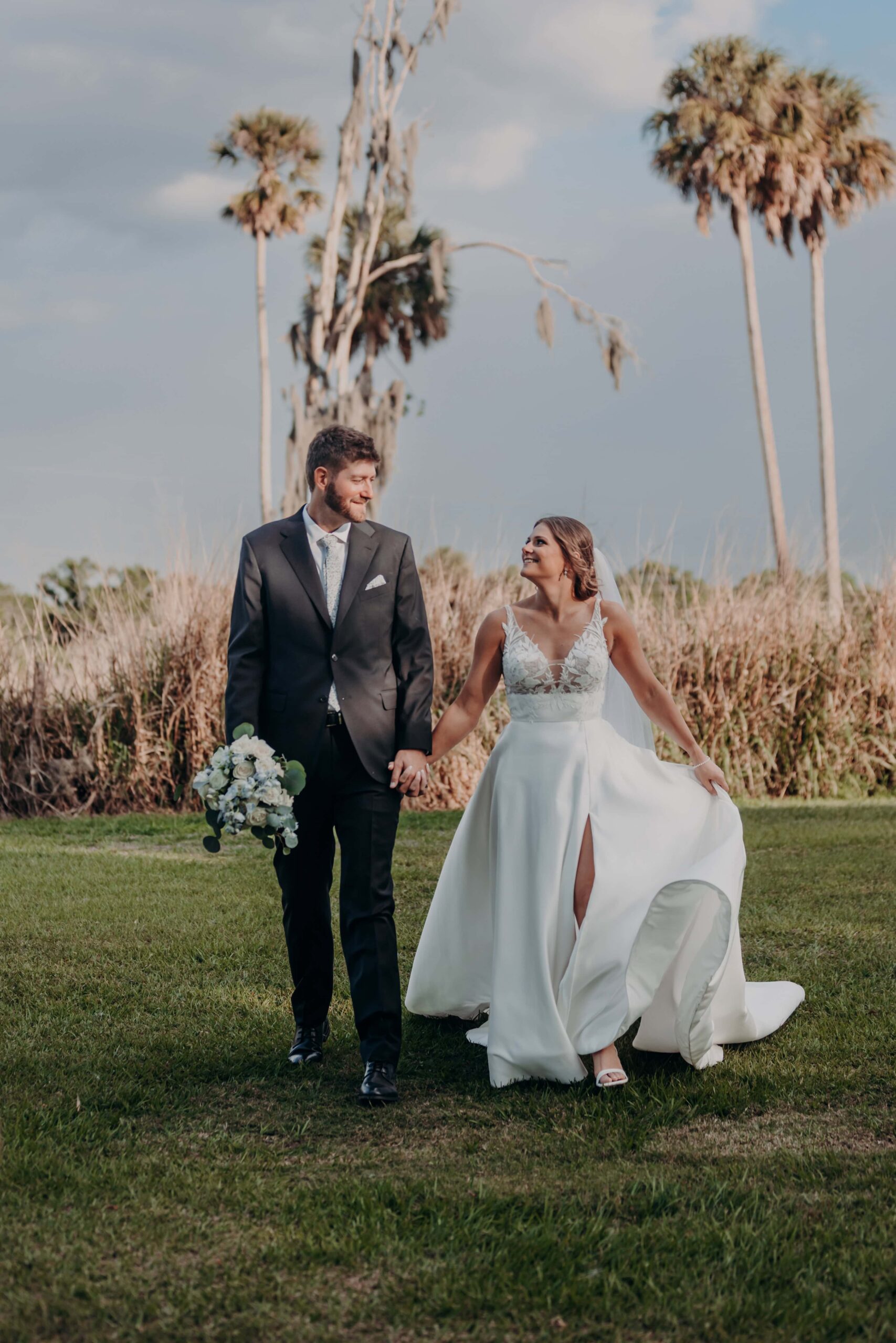 Hidden Acres wedding bride and groom walking among palm trees golden hour