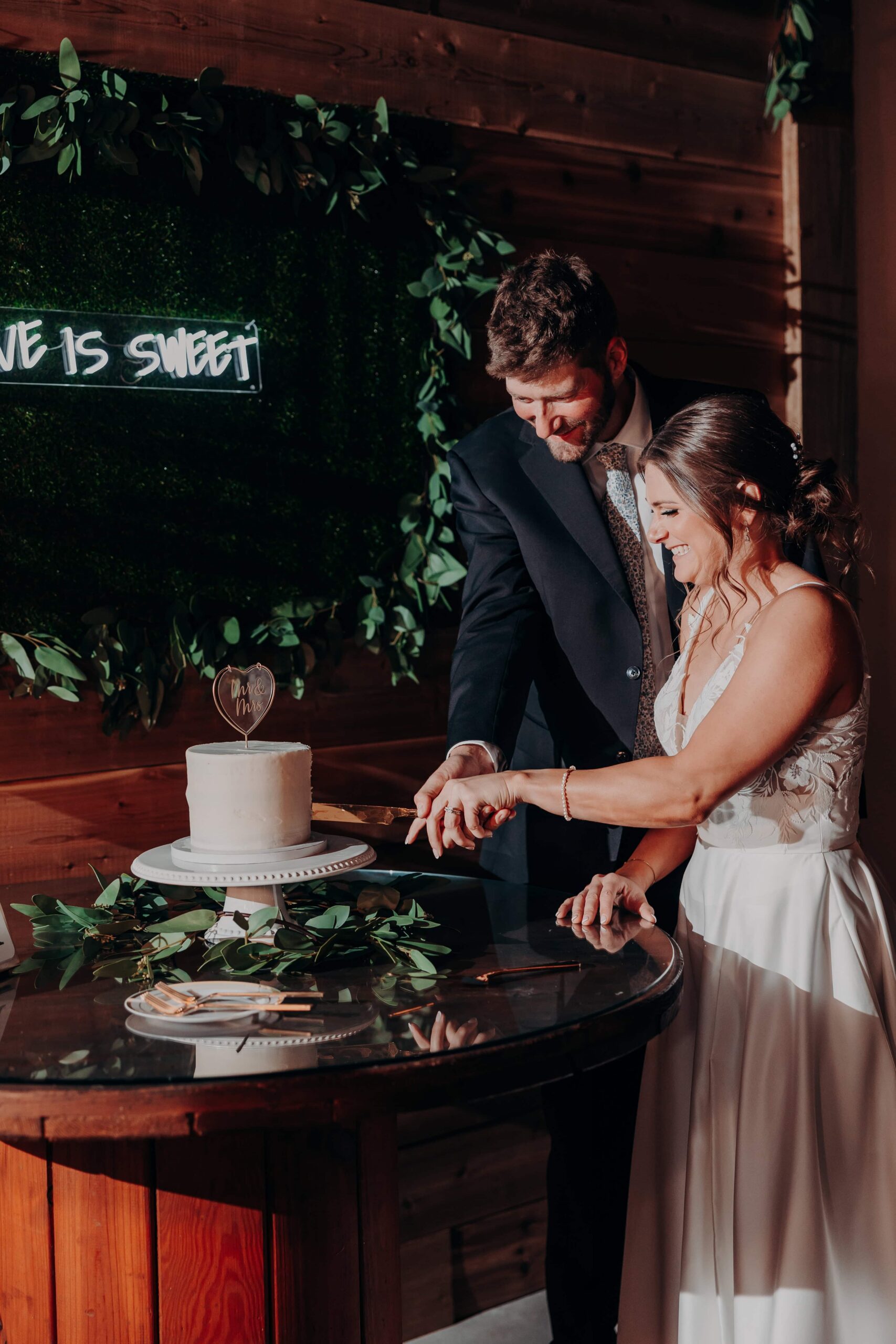 Hidden Acres wedding cake cutting with Love is Sweet neon sign