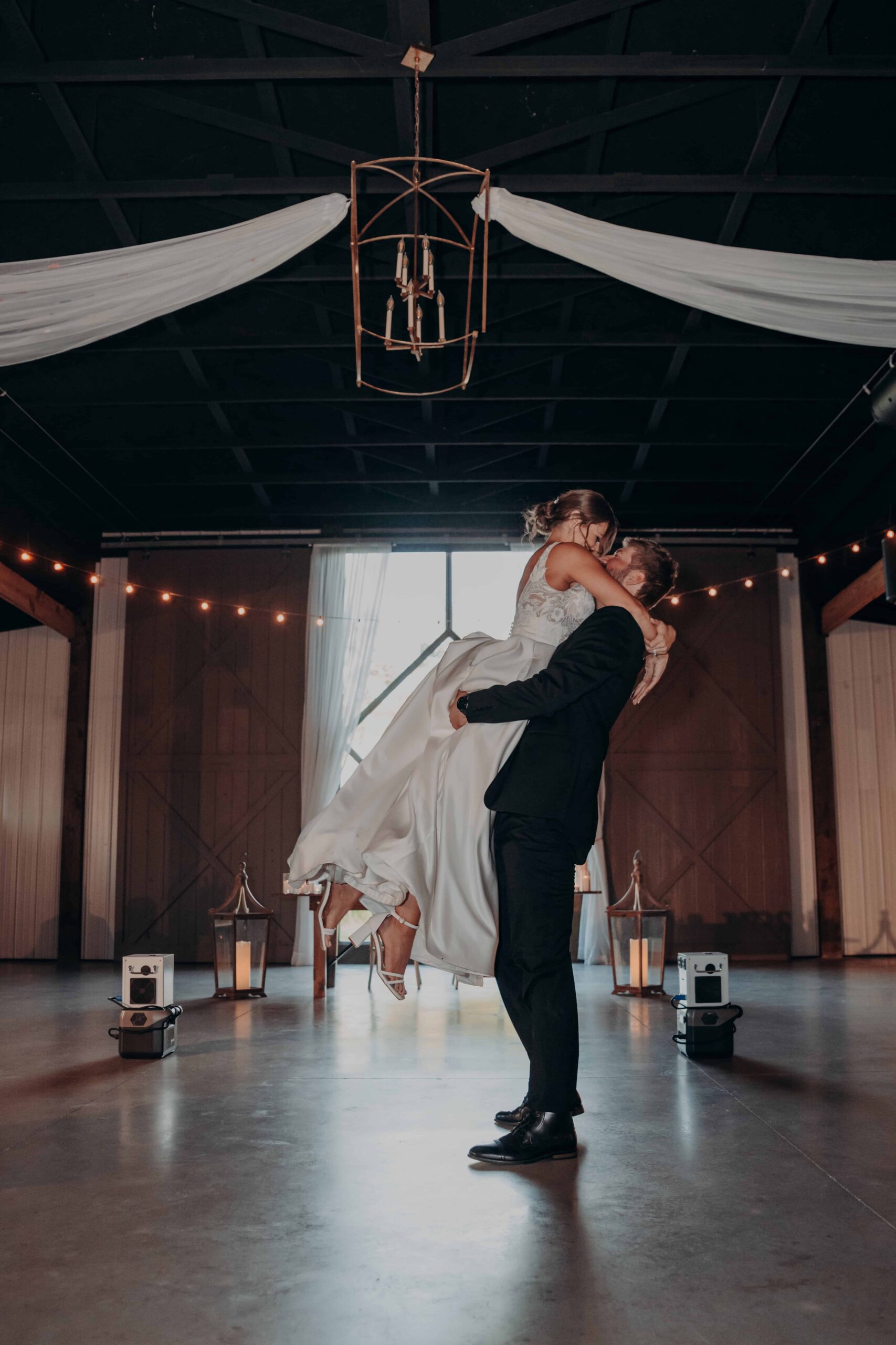 Hidden Acres wedding first dance groom lifting bride in barn
