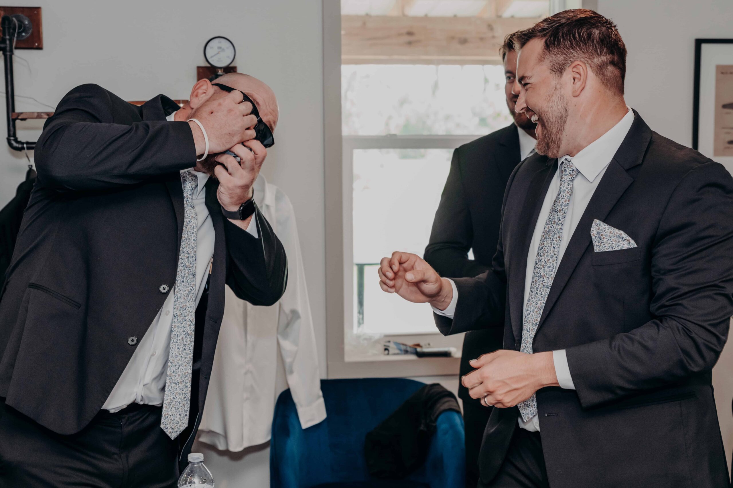 Hidden Acres wedding groomsmen getting ready laughing